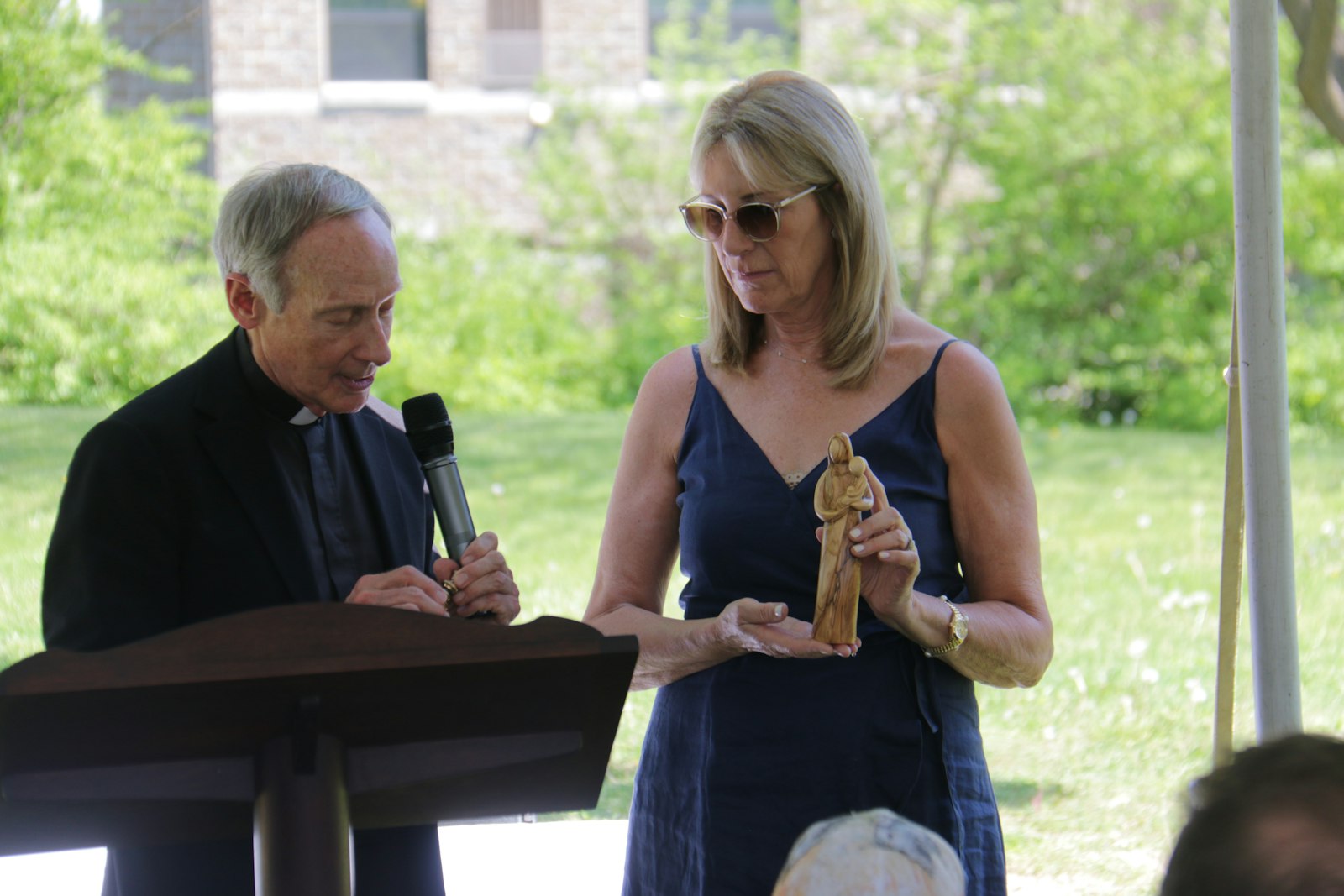 Monseñor John Zenz, capellán de la Sociedad del Niño Jesús de Detroit, bendice una estatua de María y el Niño Jesús sostenida por Mari MacKenzie de la Sociedad del Niño Jesús el 15 de mayo.