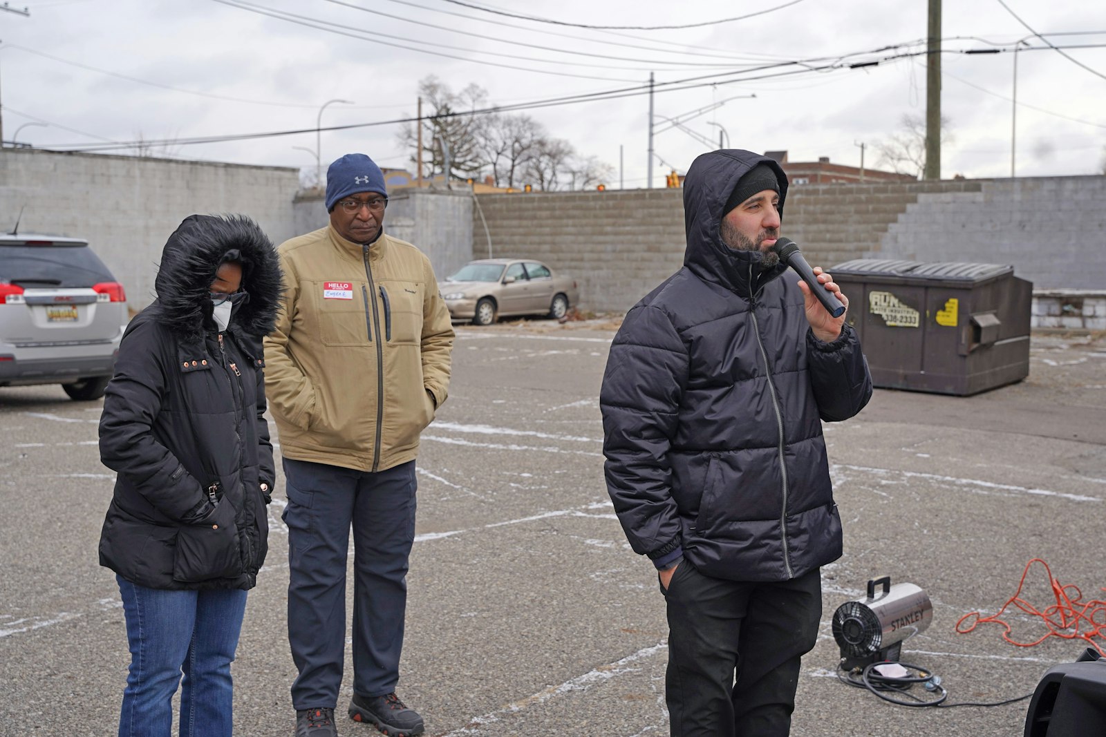 Fr. Marko Djonovic of St. Moses the Black Parish, right, says a prayer before opening the Holy Family Christmas Store at St. Charles Lwanga Parish on Dec. 17. Fr. Djonovic said the market is designed to empower parents to select their own gifts to give to their children for Christmas.