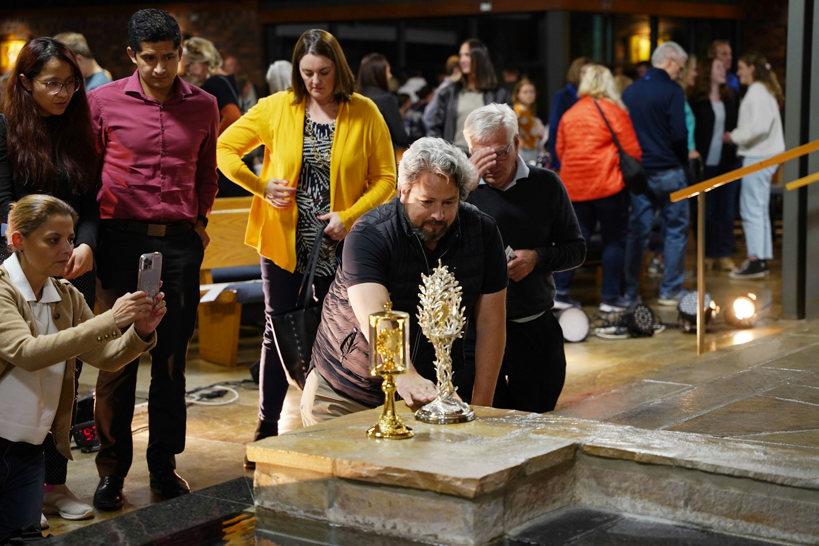 People venerate a relic of St. John Paul II after Christopher West's talk. An estimated 500 people were at St. Joseph Parish in Lake Orion for West's John Paul II-themed talk "Made for More."