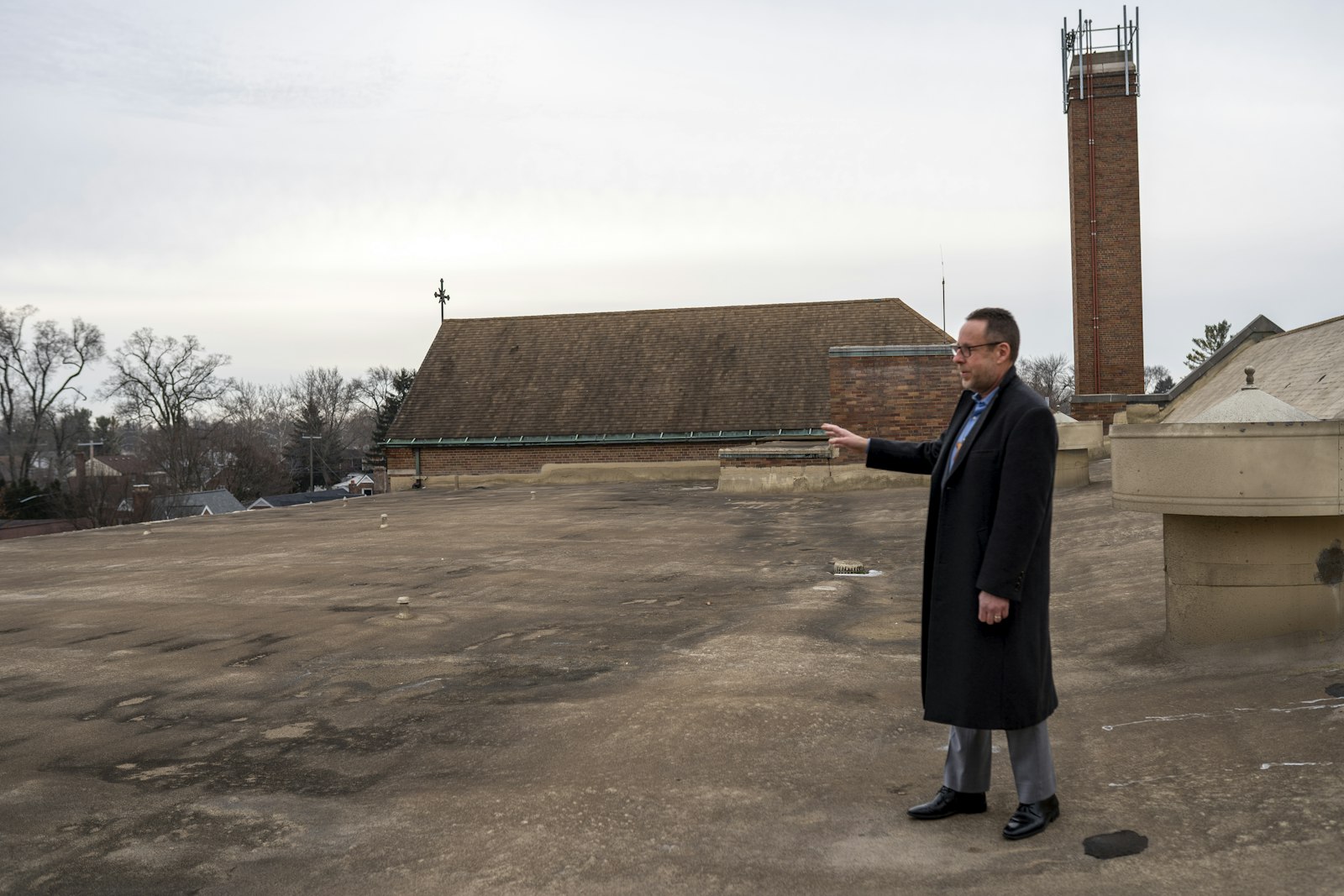 Steve Wasko, the director at St. Suzanne Cody Rouge, gestures to the flat rooftops where the center will install it's new solar panels thanks to the grant.