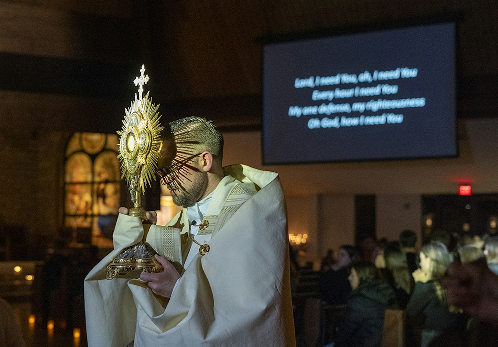 Fr. Drew Mabee, a priest in solidum serving with the Northwest Macomb 1 Family of Parishes, holds aloft Jesus in the Blessed Sacrament during adoration at the Church of the Holy Family in Novi during a "Come, Encounter Christ!" evening of praise, worship and adoration for middle and high school students Oct. 27. (Photos by Valaurian Waller | Detroit Catholic)