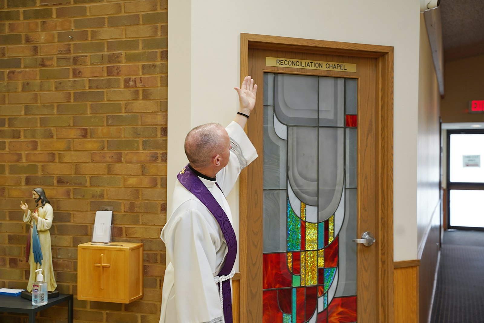 Fr. Dawson points out the sign on Prince of Peace's reconciliation room, which was recently refurbished with the help of parishioners, who donated $20,000 for the project, as well as to purchase new sacred vessels to be used during Mass.