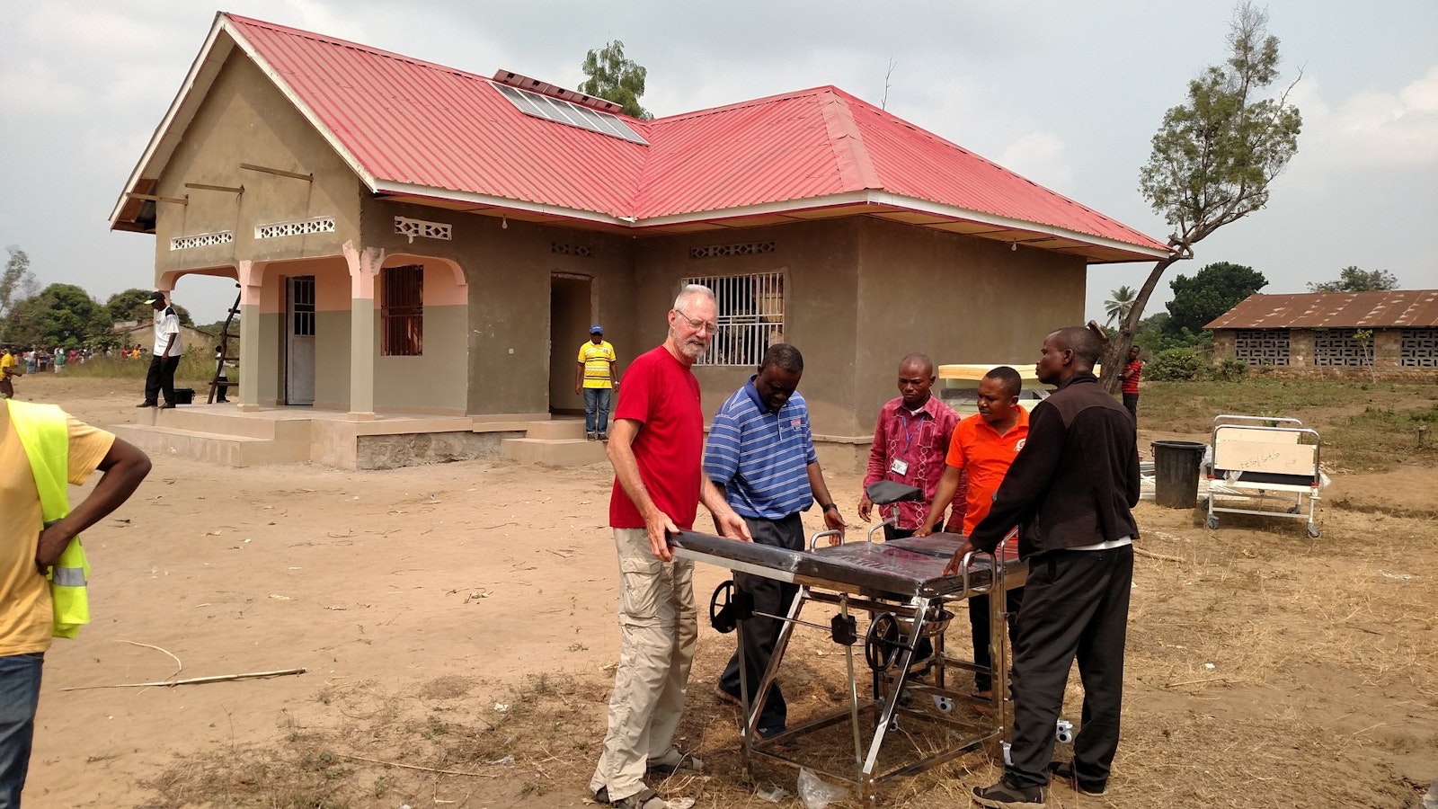 Deacon Joe Hulway (red shirt), Fr. Ikanga and local doctors examine a delivery table purchased for the Yassa women's maternity clinic, which finished construction and was dedicated in July 2019.