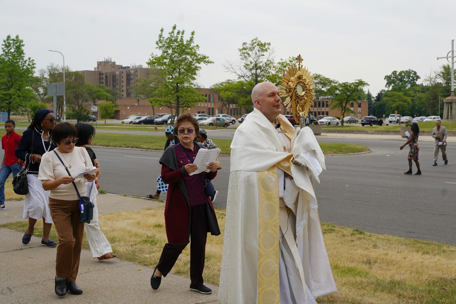Fr. Jim Lowe, CC, of St. Scholastica Parish in northwest Detroit, carries the monstrance in procession through the Evergreen-Outer Drive neighborhood June 11. St. Scholastica and neighboring parishes hosted a 40 hours' devotion leading up to the feast of Corpus Christi, including praise and worship and Eucharistic adoration throughout the night leading up to the solemnity. (Daniel Meloy | Detroit Catholic)
