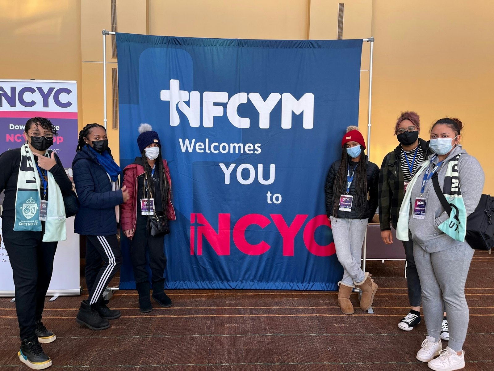 Youth from St. Juan Diego Parish and Corpus Christi Parish in Detroit post with a welcome banner at the National Catholic Youth Conference in Indianapolis. Teens from 12 of the Archdiocese of Detroit's 16 vicariates were represented at the three-day conference.