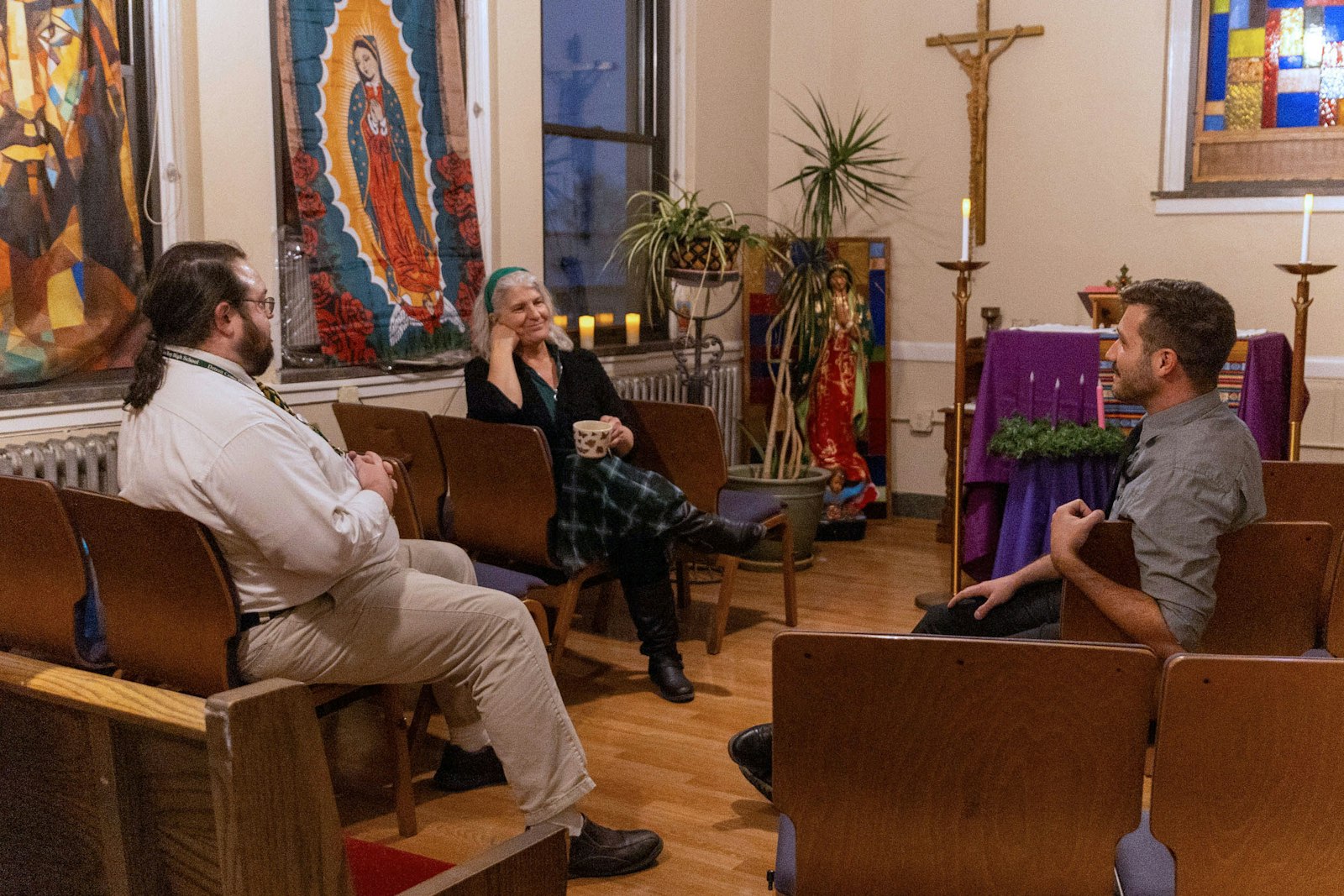 Artist Jeremy Alexander, right, speaks with campus minister Kim Redigan, center, and Latin teacher Jim Dwyer in the chapel of Detroit Cristo Rey High School in southwest Detroit. The chapel is open to students and staff to pray throughout the school day.