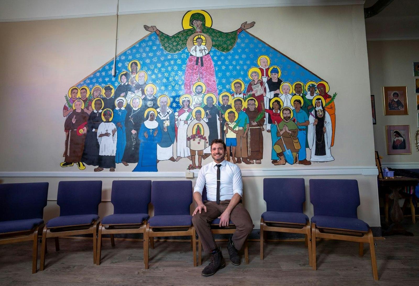 Cristo Rey theology teacher Jeremy Alexander painted the new mural in the school's chapel, which features Mary, Jesus and a diverse array of saints.