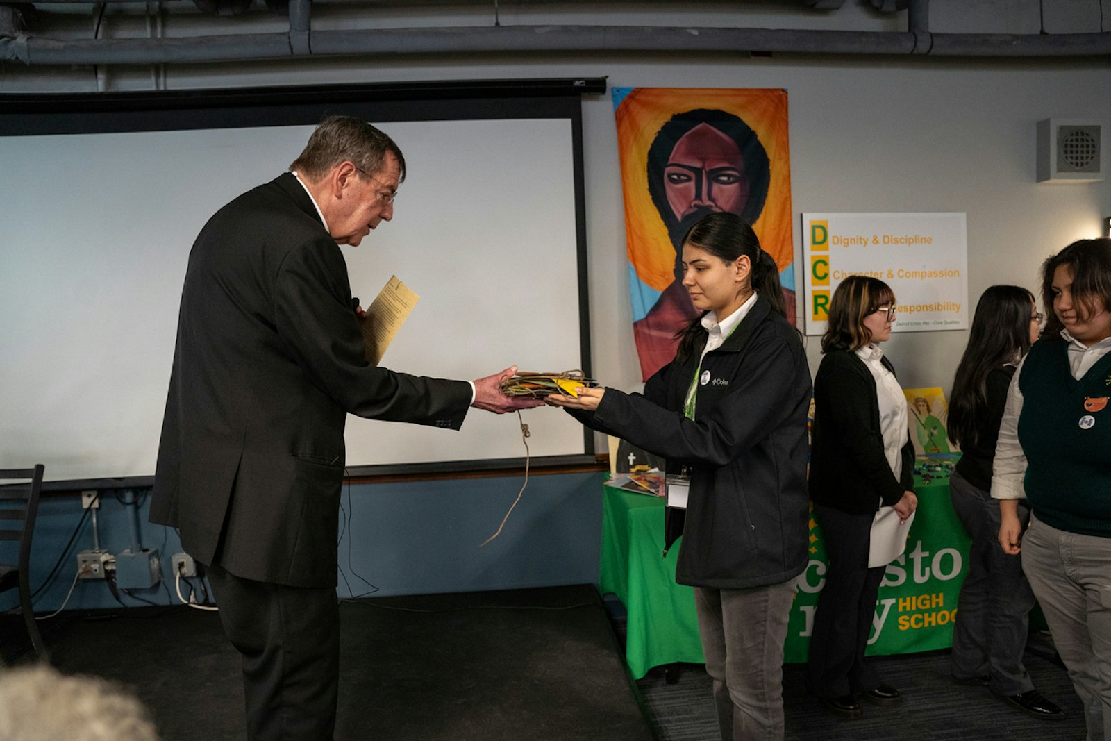 Cristo Rey students offer Archbishop Vigneron a stack of handmade cards expressing support and prayers for migrants and gratitude for the Church's love.