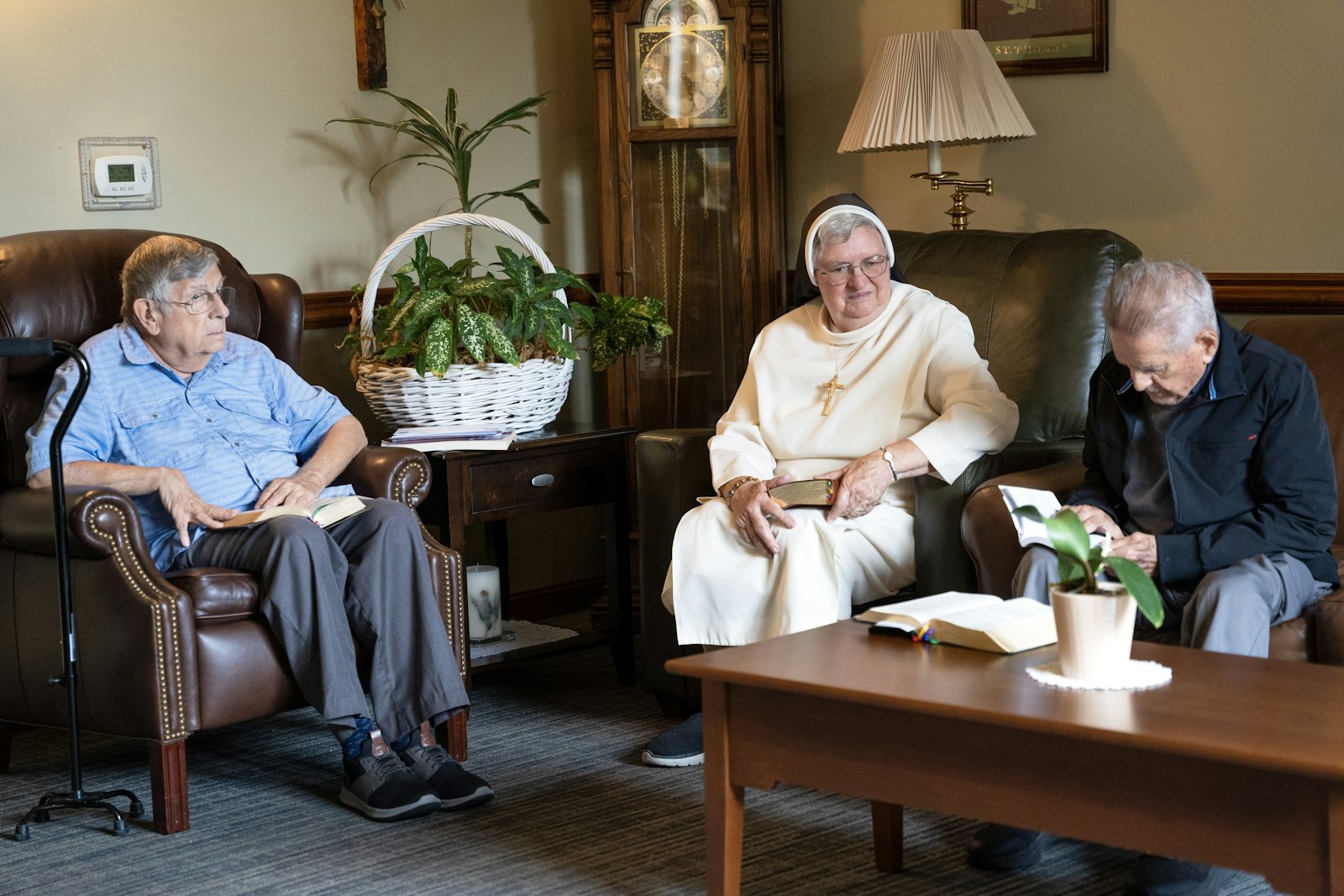 Fr. Leliaert,  Sr. Beatrice Marie Plamodon and Fr. Phalen sit together in the community center to say evening prayers. The priests regularly meet in the center for prayer and fellowship, and eat dinner there 5 nights a week.