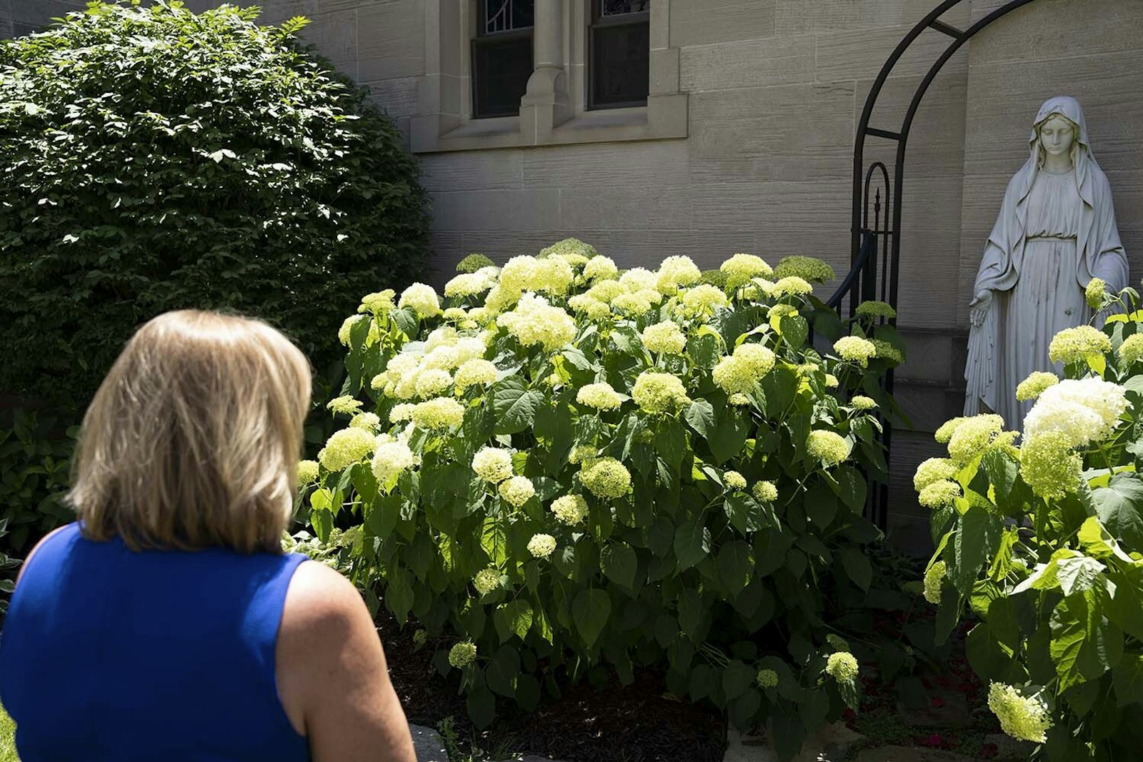 Linda Maccarone prays in the Marian garden at St. Mary Parish. Even though mission support directors manage the "behind the scenes" aspects of parish life, everything must start with prayer, she said.