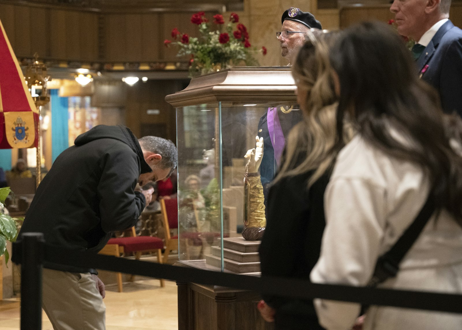 Linda Kanna's husband venerates the relic as her daughters wait in line.