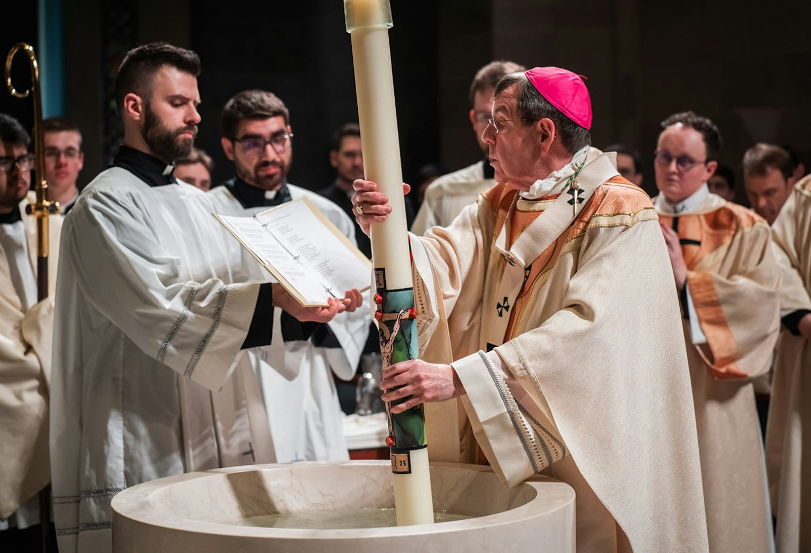 Archbishop Vigneron blesses the Easter candle during the Easter vigil April 8 at the Cathedral of the Most Blessed Sacrament. Christ's rising from the dead helps us to better understand the sacraments, which is why it is so fitting that those entering the Church should do so on Easter, the archbishop said.