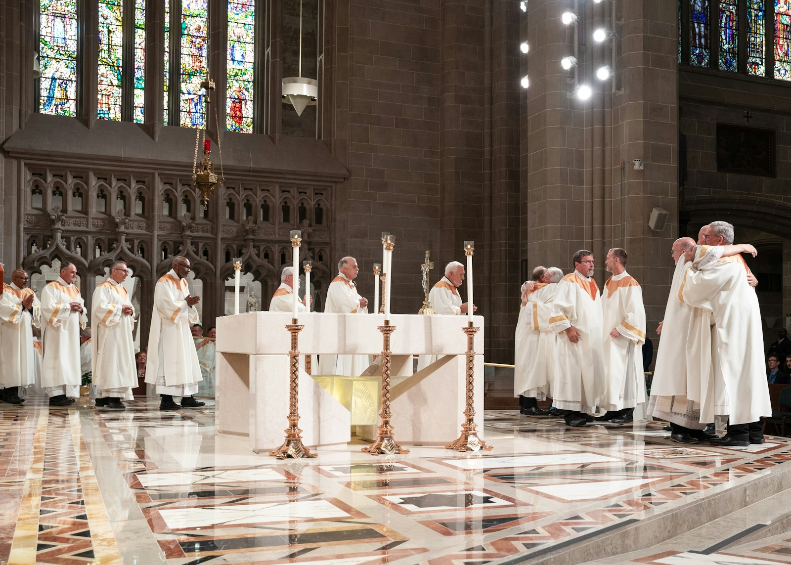 Deacons line up to embrace their four new brother deacons following their ordination.