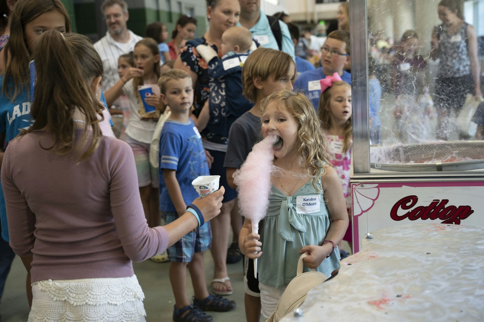 Una niña disfruta del algodón de azúcar, una de las varias atracciones para niños y familias durante la celebración del 25to aniversario. Una hermana calificó el evento de "reunión familiar".