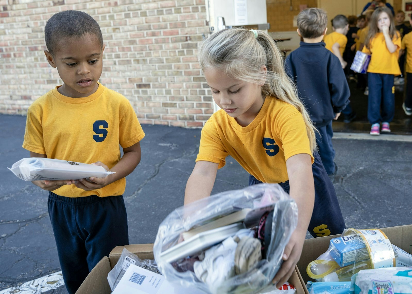 Al comienzo de la jornada escolar del 10 de octubre, los alumnos de Shrine, desde preescolar hasta quinto grado, se turnaron para ir a la cafetería y cargar el camión con las donaciones de los miembros de la escuela y la iglesia de Shrine, así como de los vecinos de Royal Oak.