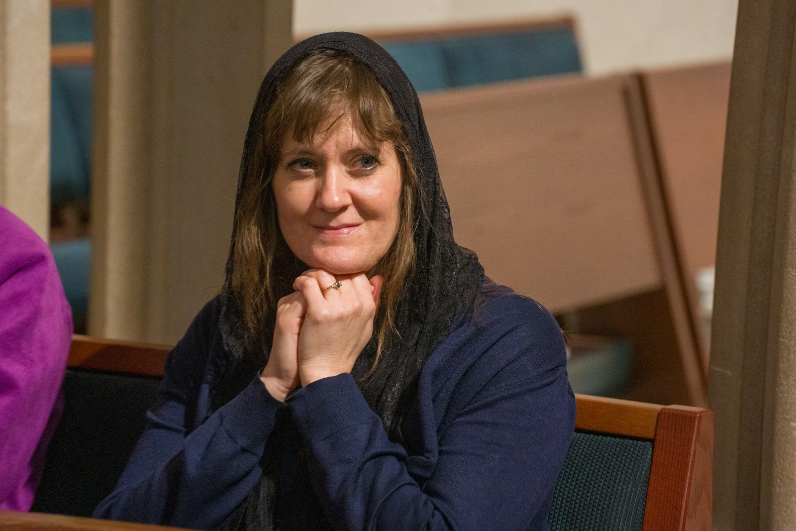 A woman smiles while praying during the Rite of Election on March 6 at the Cathedral of the Most Blessed Sacrament. Candidates and catechumens, along with their sponsors, took part in the ceremony, during which those preparing to enter the Church make public their intentions.