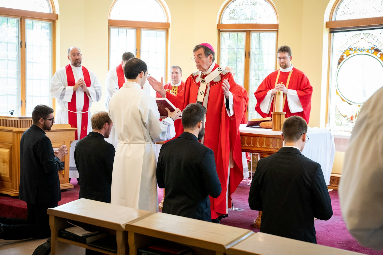 Archbishop Vigneron prays over the four men during the Rite of Candidacy. The annual Mass is similar to the ancient Rite of Betrothal, the archbishop said, during which no vows are taken, but a couple continues to discern their vocation in a more public fashion.