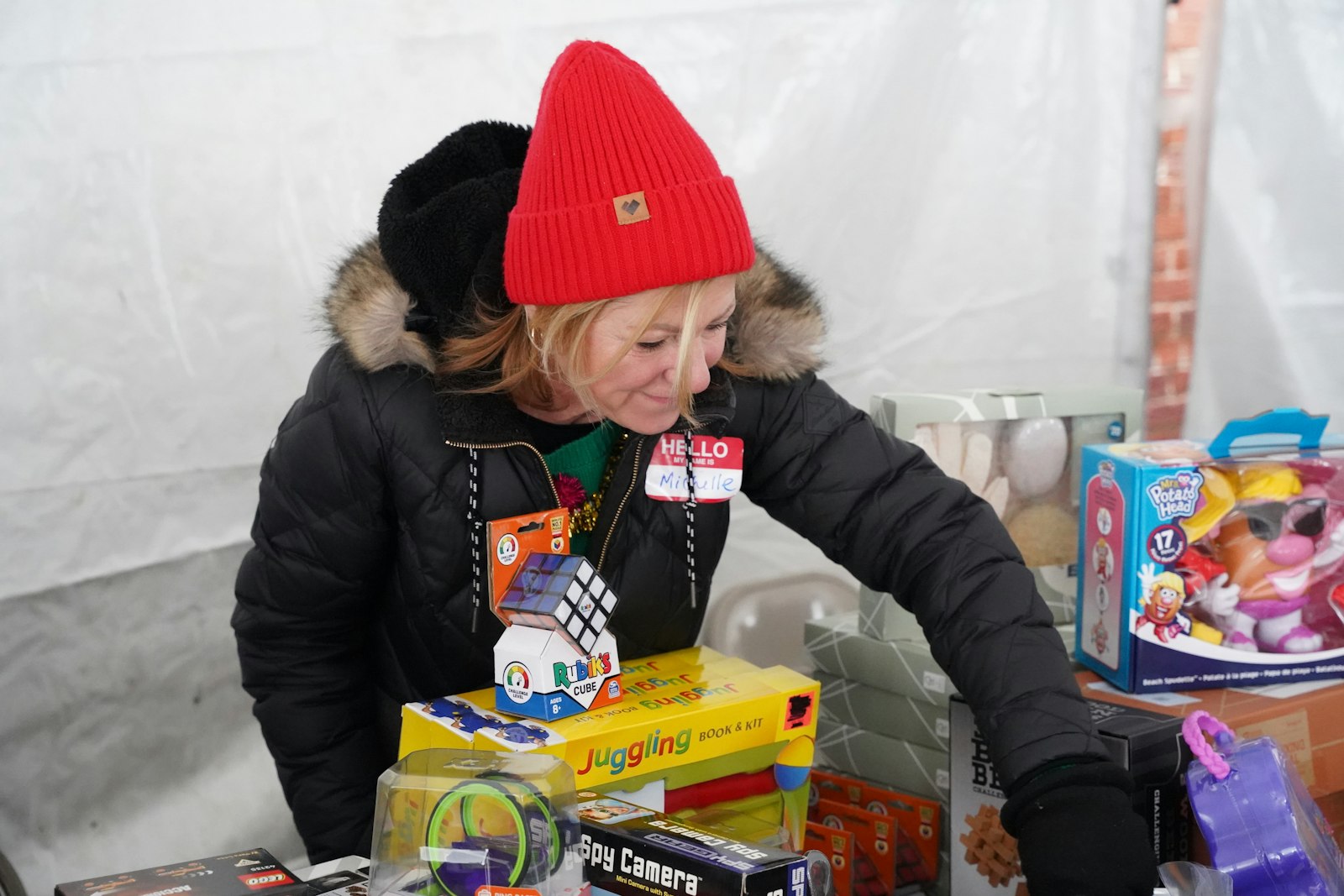 A volunteer organizes gifts available for parents to choose from. Each guest at the Holy Family Christmas Store was paired with a volunteer assistant shopper who guided the guest through the store, helping select items and carrying their items to the car.