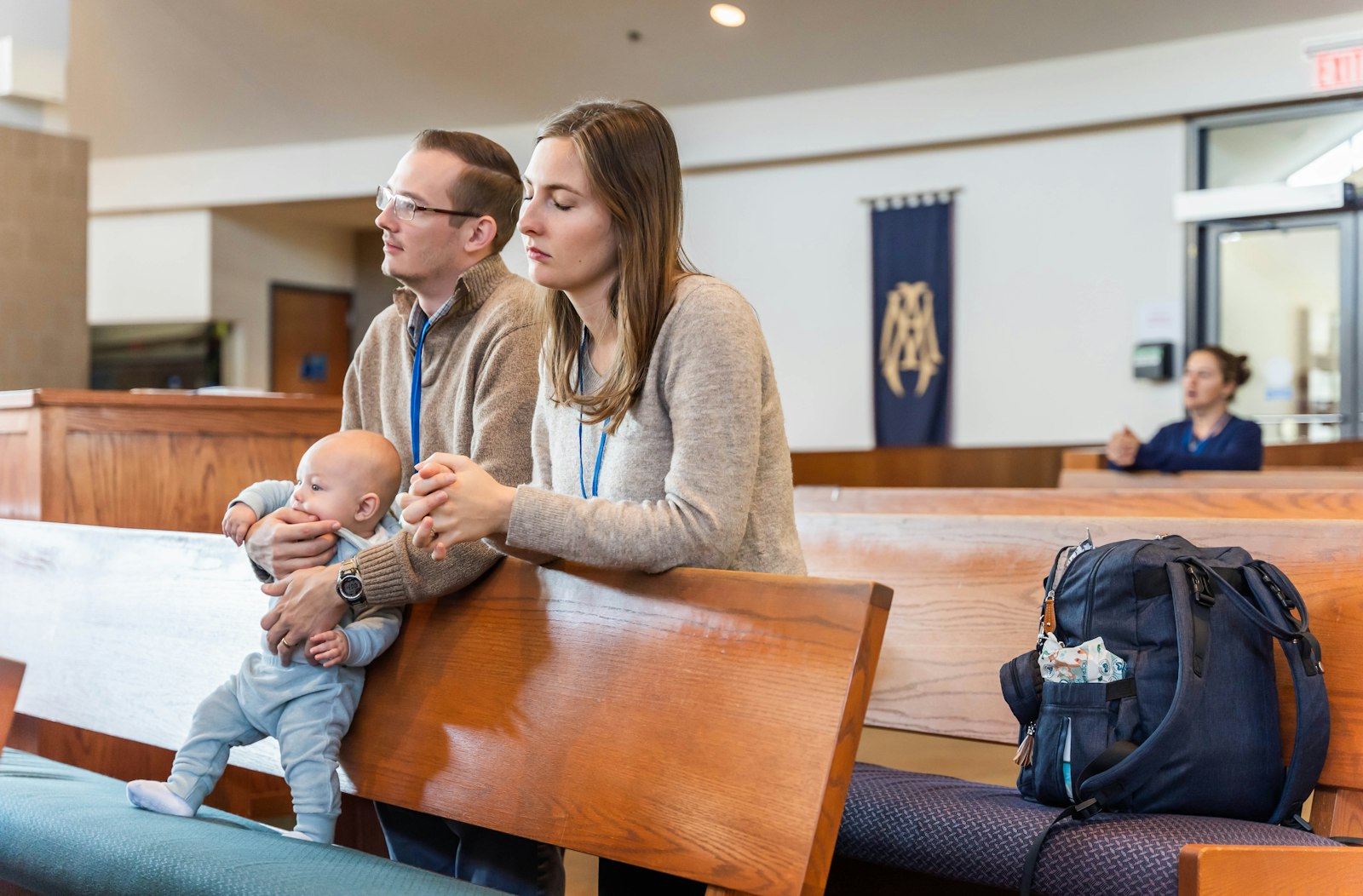 Paul and Andrea Spankie of St. Peter Parish in Mount Clemens pray as they hold their son, Theo, during Mass to begin the Together in Holiness conference Oct. 15 at Our Lady of Good Counsel Parish in Plymouth.
