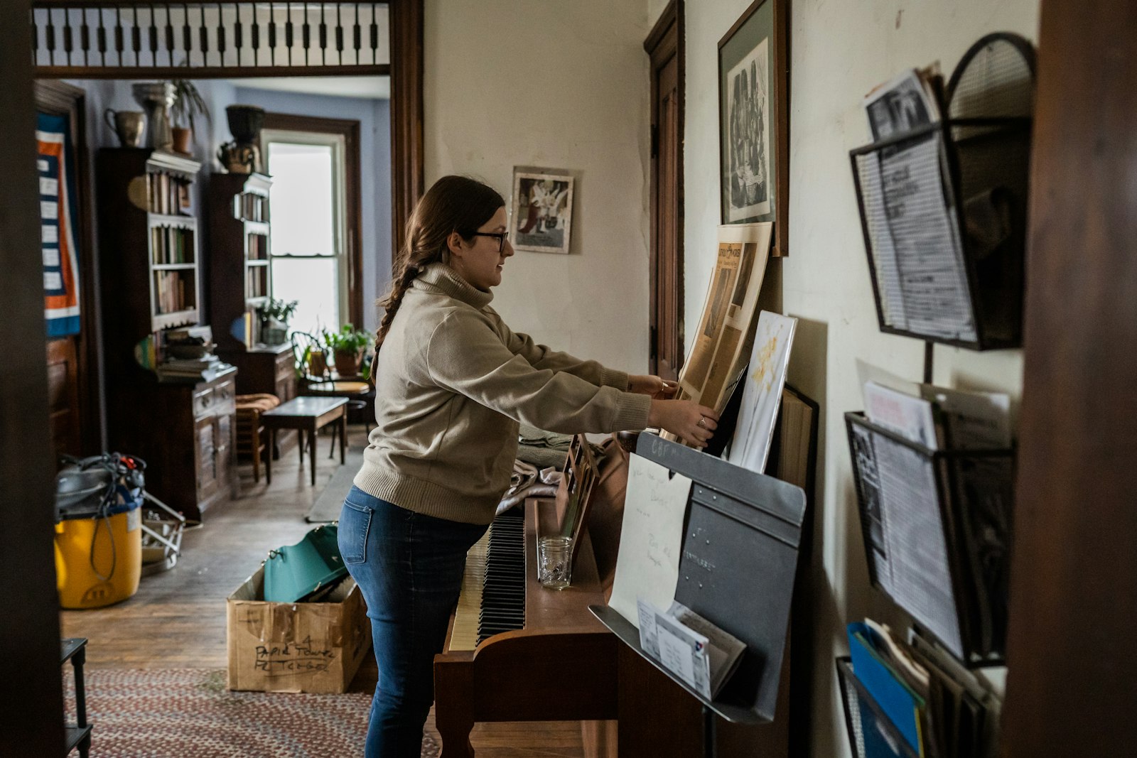 Jordan Kennedy places a newspaper article about the Catholic Worker community on the wall of the Day House on Trumbull Avenue. The worldwide Catholic Worker community was co-founded in the 1930s by Dorothy Day.