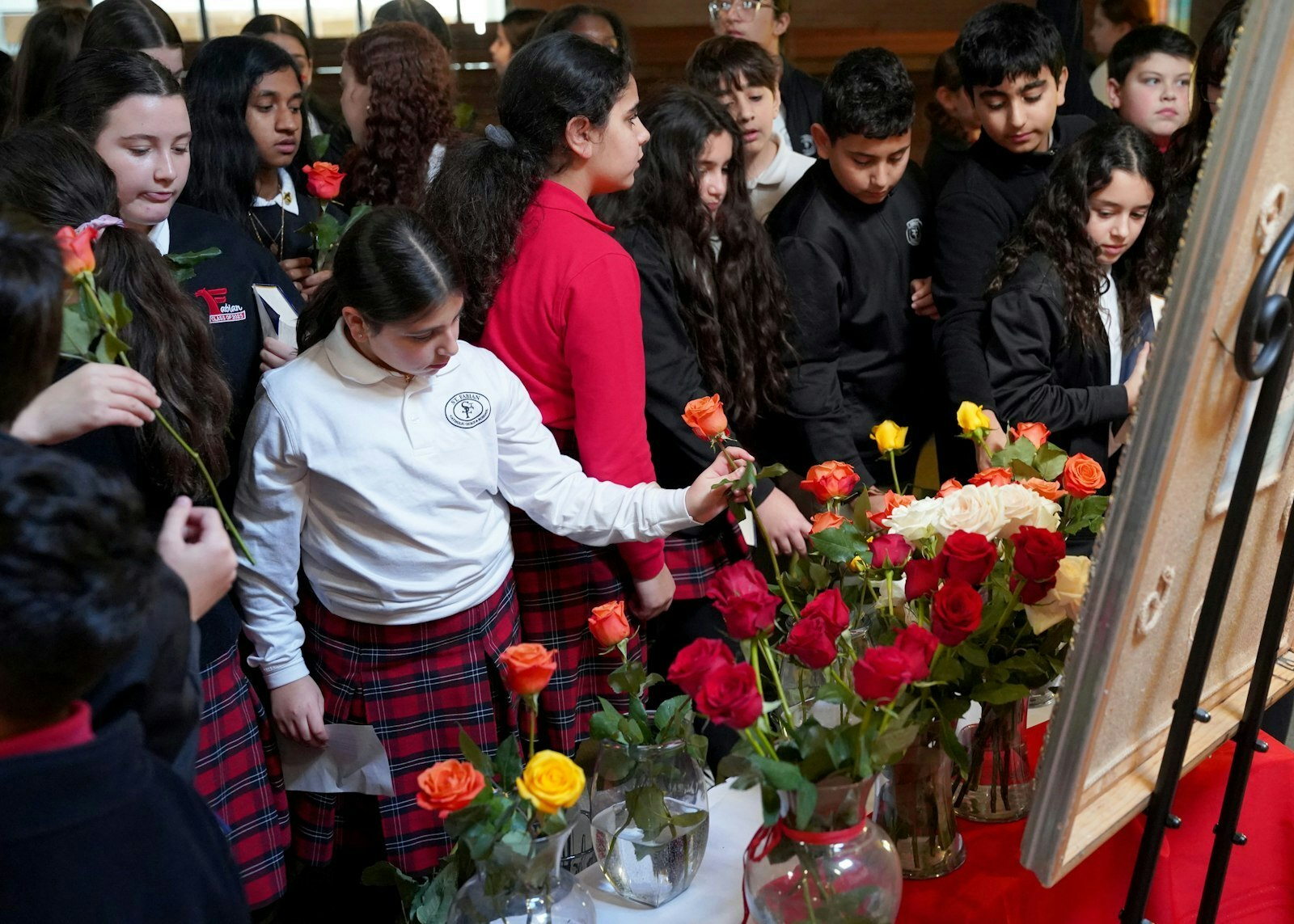 Los alumnos de St. Fabian colocan rosas ante una imagen de la Virgen el 12 de diciembre. Kerwin y el P. Kurt pensaban que no se registrarían más de 10 alumnos, pero se inscribieron 70 y completaron la consagración hasta el final.