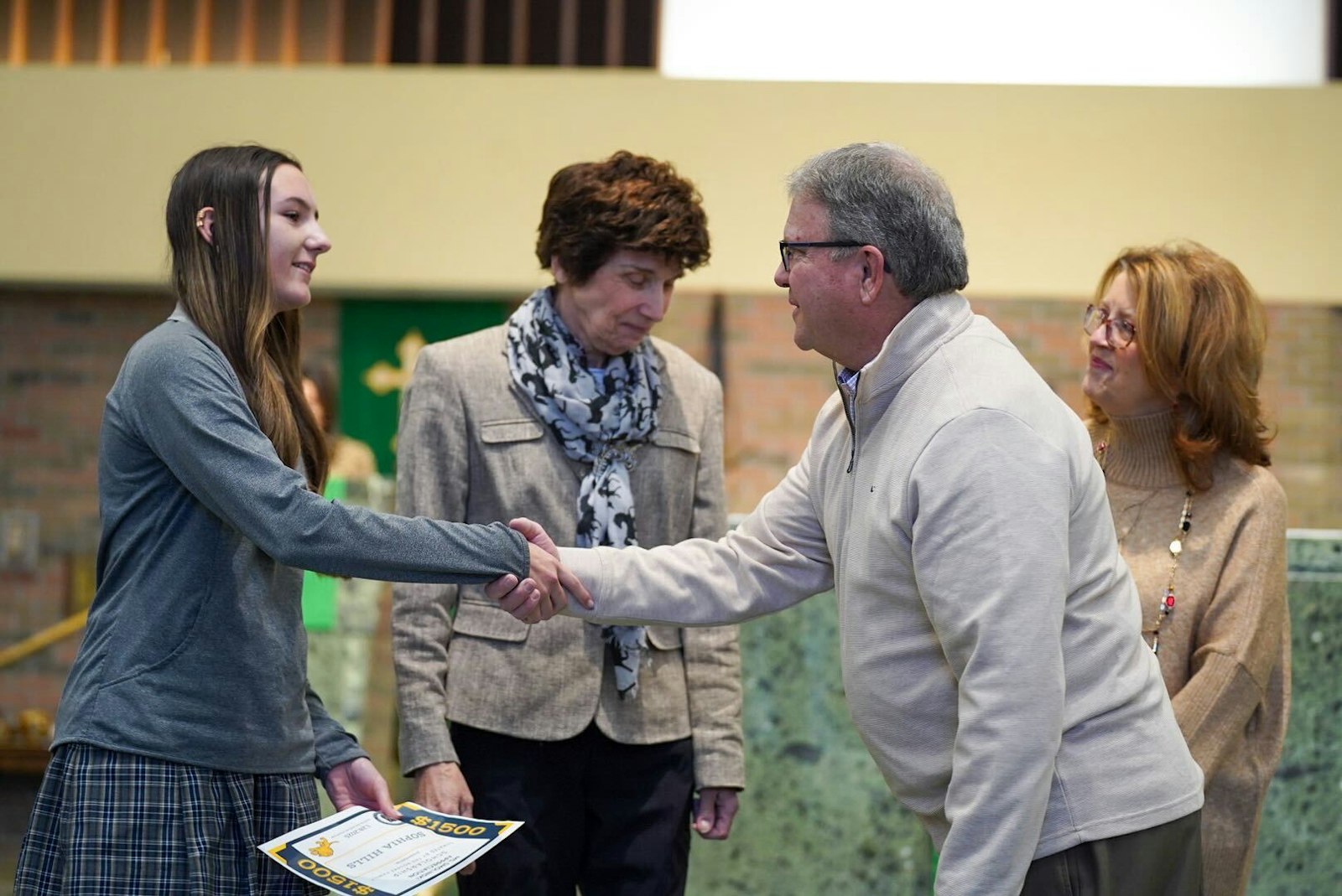 Kevin and Karen Rourke congratulate Cabrini student Sophia Hills on being awarded a scholarship the Rourkes sponsored in honor of Patricia Smolinski, who taught 42 years at Cabrini.