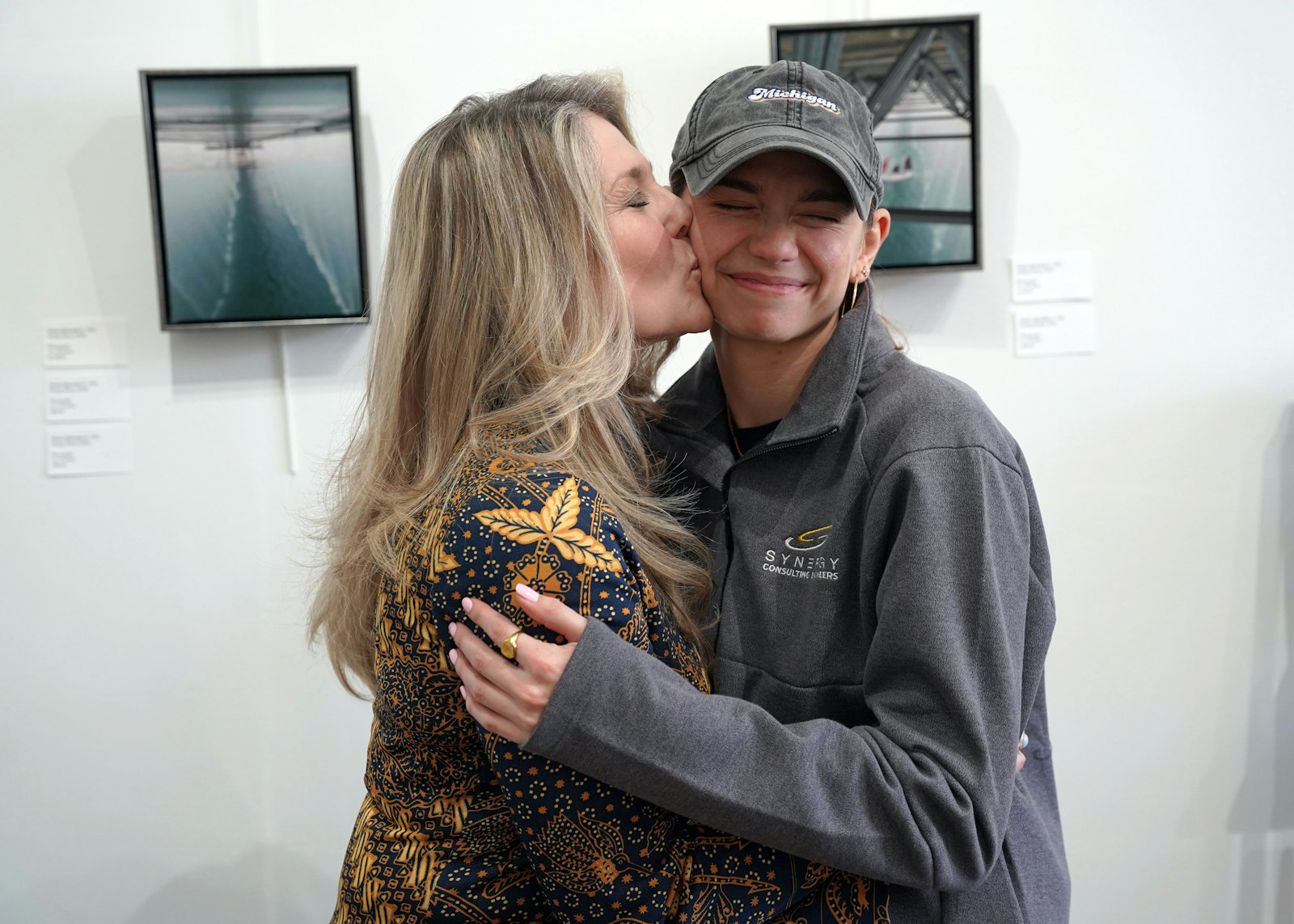 Jeanette and her daughter, Ariana, pose in front of some of Ariana's photography.