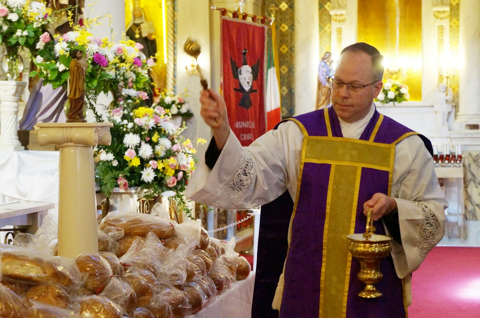 Fr. Paul Ward, pastor of Holy Family Parish in Detroit, blesses St. Joseph's Day bread after Mass on March 20. The parish was founded in 1909 by Italian immigrants, many of whom came to the United States with their own traditions, including special celebrations in honor of St. Joseph.