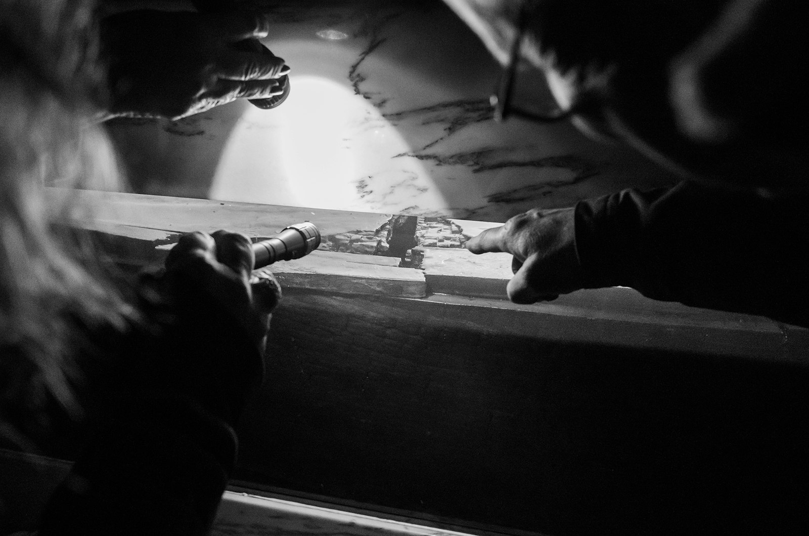 Visitors check out the tomb of Fr. Gabriel Richard at the Basilica of Ste. Anne on Oct. 25, illuminated with flashlights during "Ste. Anne After Dark," a look inside the famed church's history, saintly stories and Catholic teaching on the meaning of death. (Photos by Valaurian Waller | Detroit Catholic)