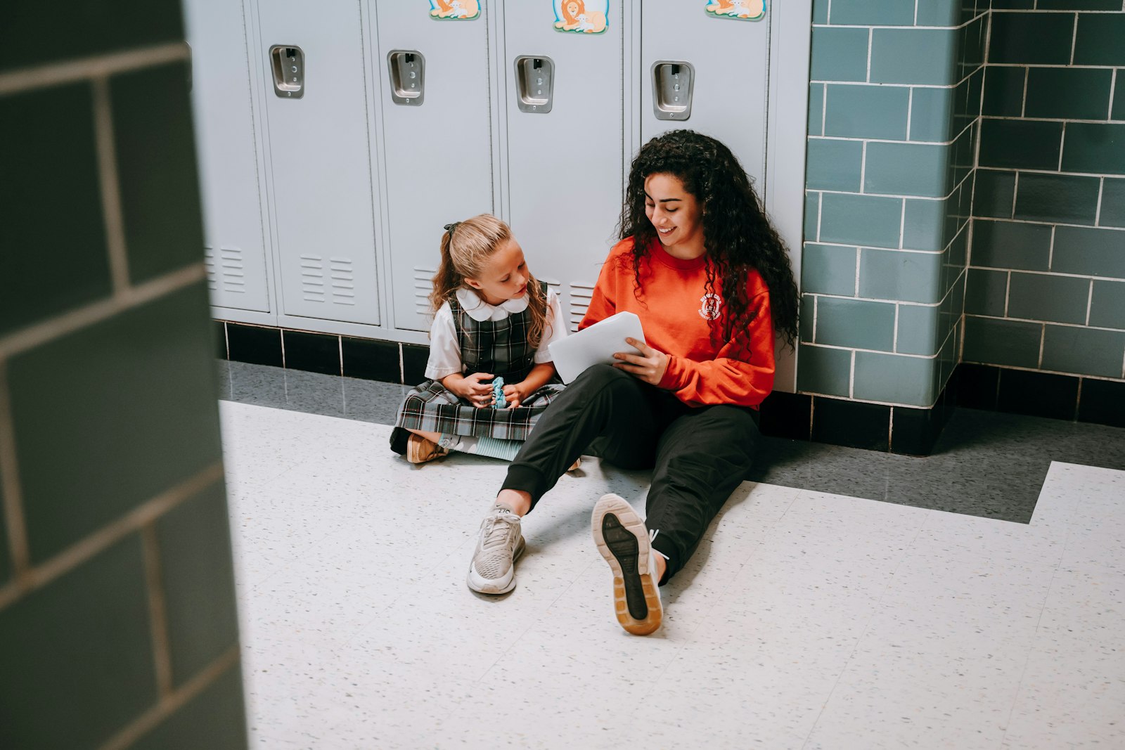 Un estudiante de secundaria de la escuela secundaria Divine Child en Dearborn lee a una estudiante más joven durante una actividad entre clases.