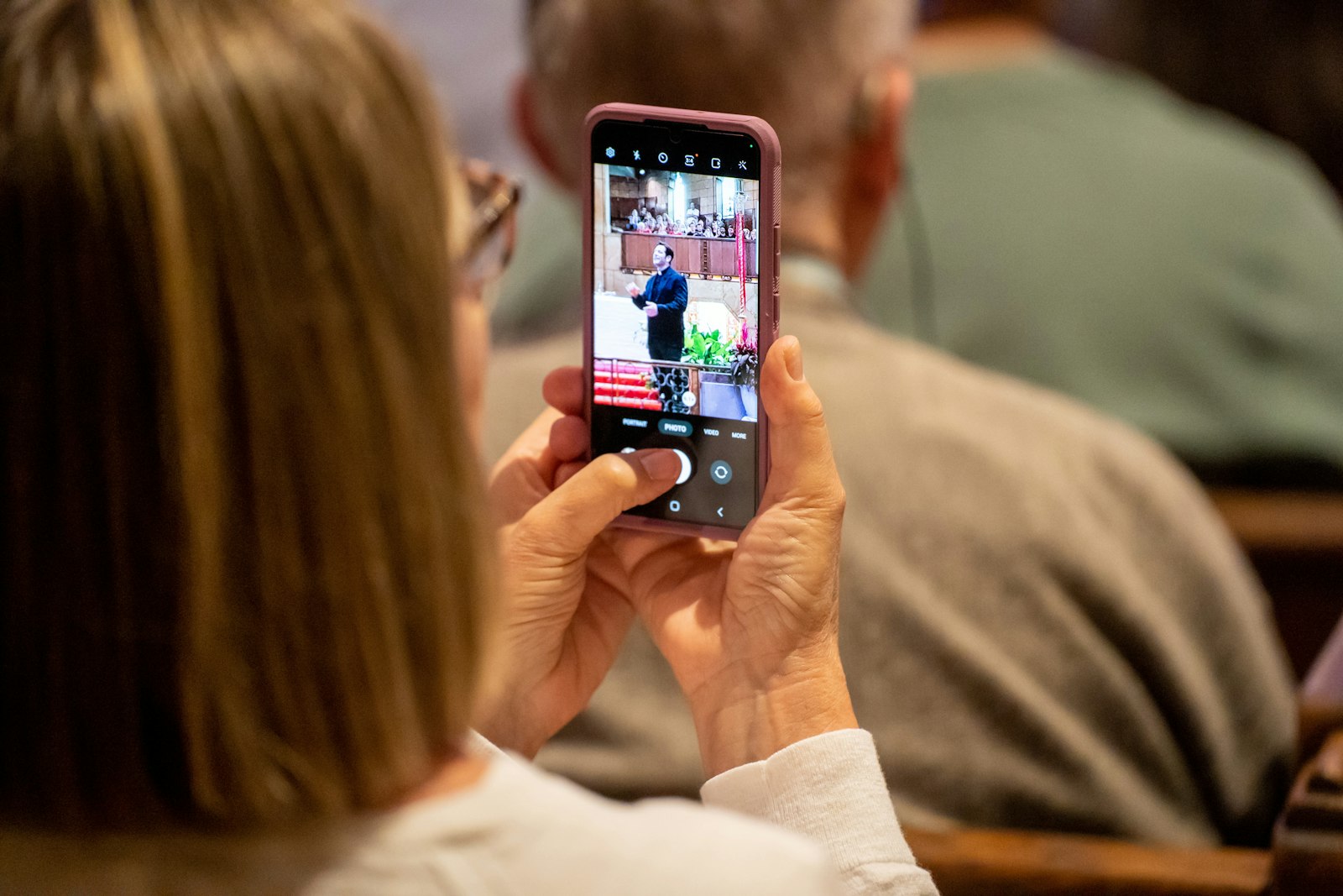 Una persona del público graba con su teléfono móvil la charla del padre Schmitz. El sacerdote de Duluth, Minnesota, es más conocido por su serie en YouTube y su popular podcast patrocinado por Ascension Press. (Valaurian Waller | Detroit Catholic)