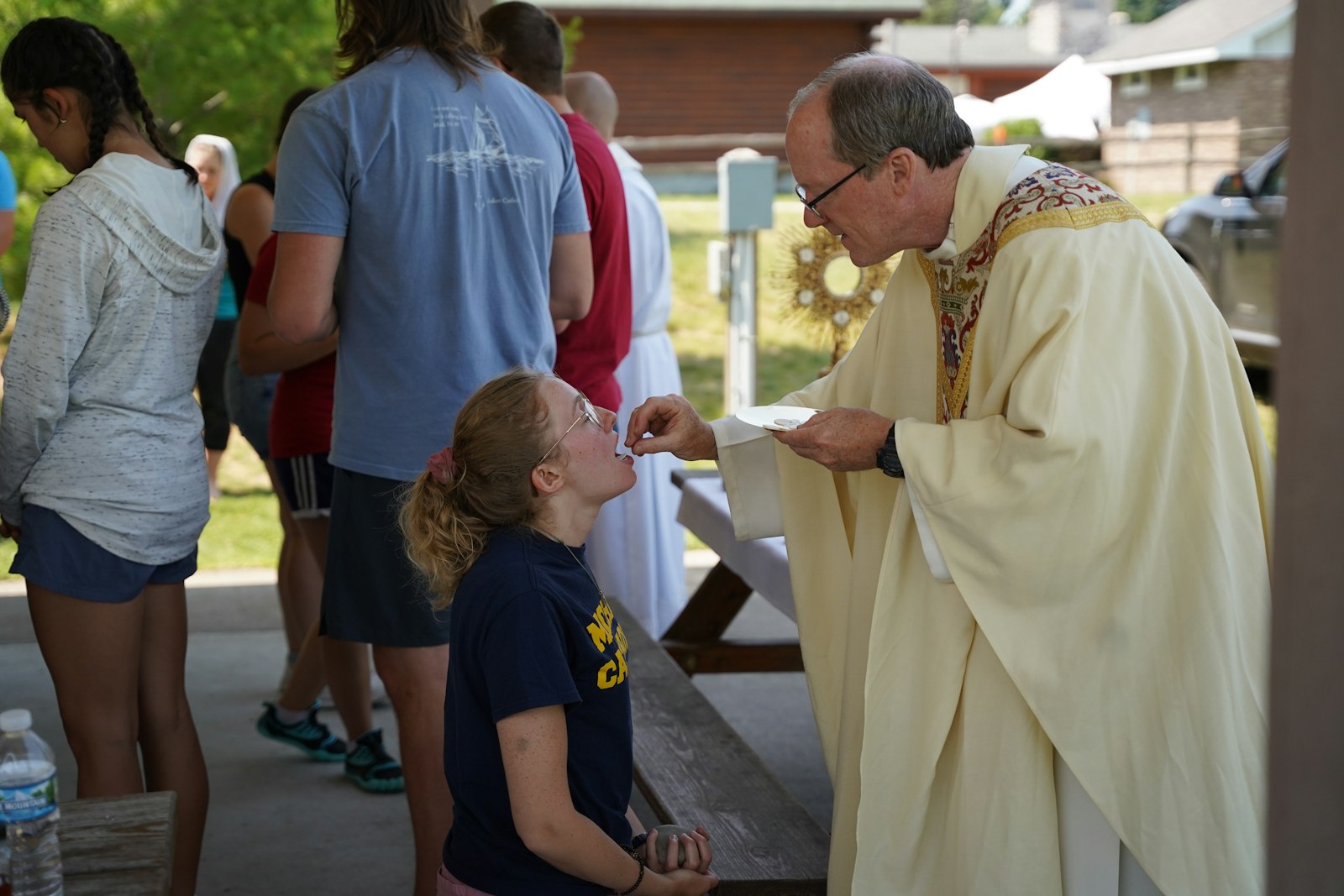 Bishop Walsh distributes Communion during the Saturday Mass in Indian River following the pilgrims' 8.5-mile hike. Bishop Walsh encouraged the young adults on the retreat to emulate St. Mary Magdalene in fulfilling the "kerygma" and pronouncing the Gospel of Jesus Christ.