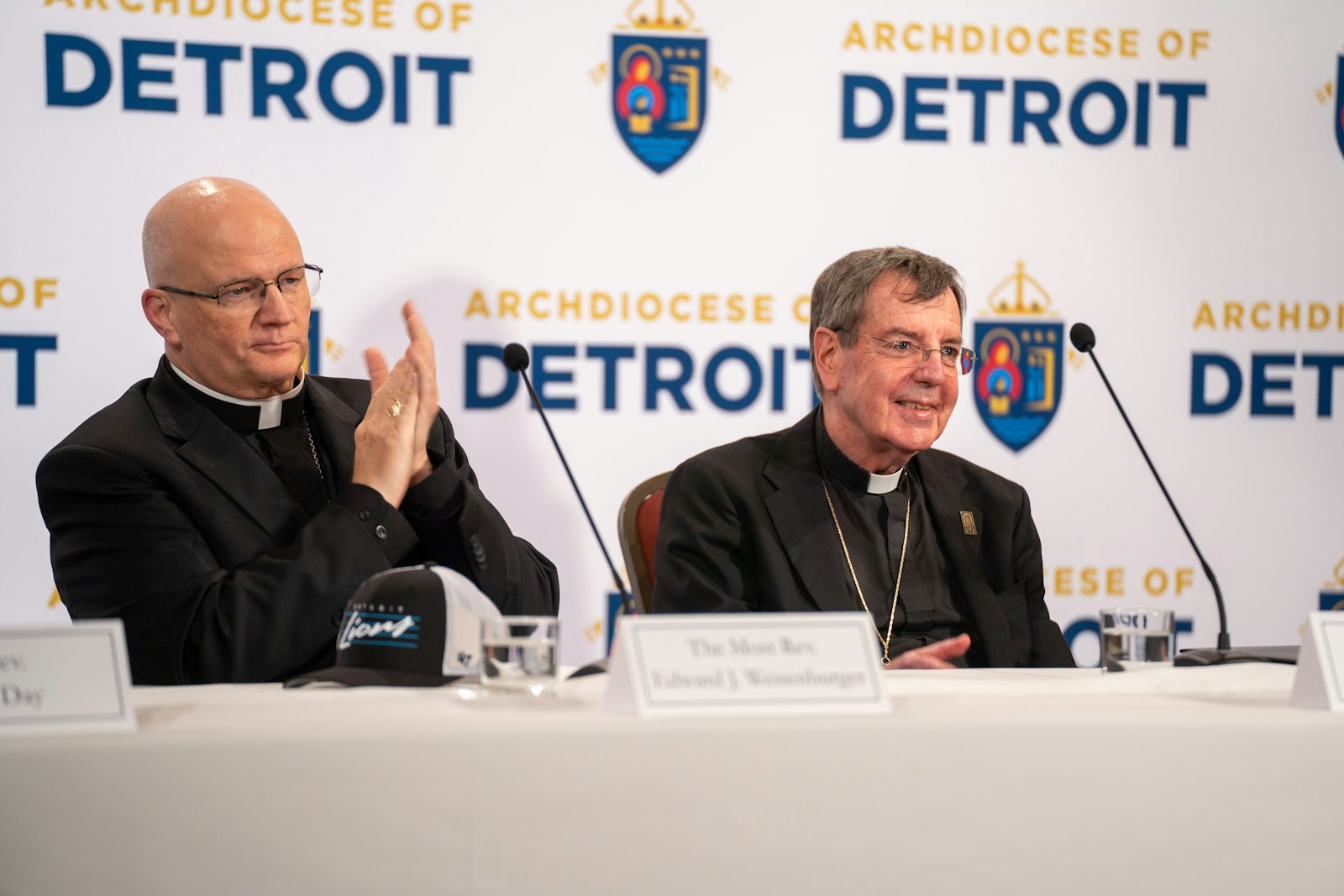 Archbishop-elect Edward J. Weisenburger leads applause for Archbishop Allen H. Vigneron during the morning news conference. Archbishop-elect Weisenburger praised his predecessor as a "faithful shepherd" who "poured yourself out so generously" for the people of the Archdiocese of Detroit.