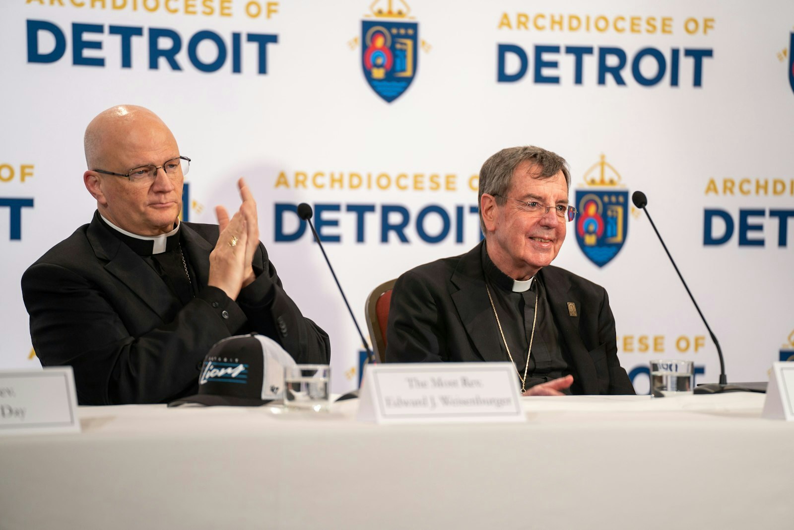 El Arzobispo electo Edward J. Weisenburger dirige los aplausos al Arzobispo Allen H. Vigneron durante la conferencia de prensa de esta mañana. El Arzobispo electo Weisenburger elogió a su antecesor como un "líder fiel" que "se entregó tan generosamente" al pueblo de la Arquidiócesis de Detroit.