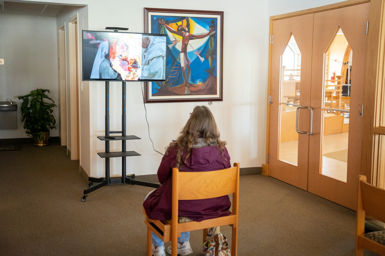 A woman watches a video that accompanies the Eucharistic miracles exhibit at St. Roch Parish in Flat Rock. Eucharistic miracles have occurred throughout the Church's history, powerful reminders of God's supernatural presence in each and every Mass.