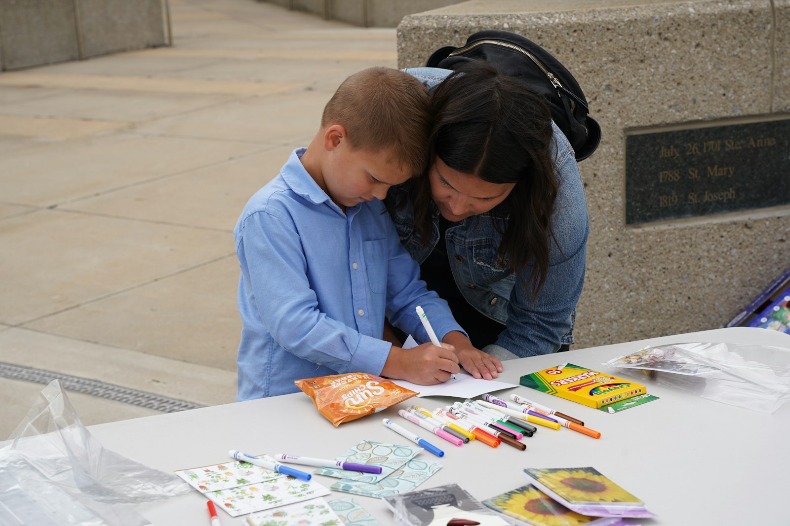 Jaime Taylor, a parishioner of Our Lady of the Lakes Parish in Waterford, helps her son, Ellis, make a card for local seniors during a service project after Mass at the Cathedral of the Most Blessed Sacrament.