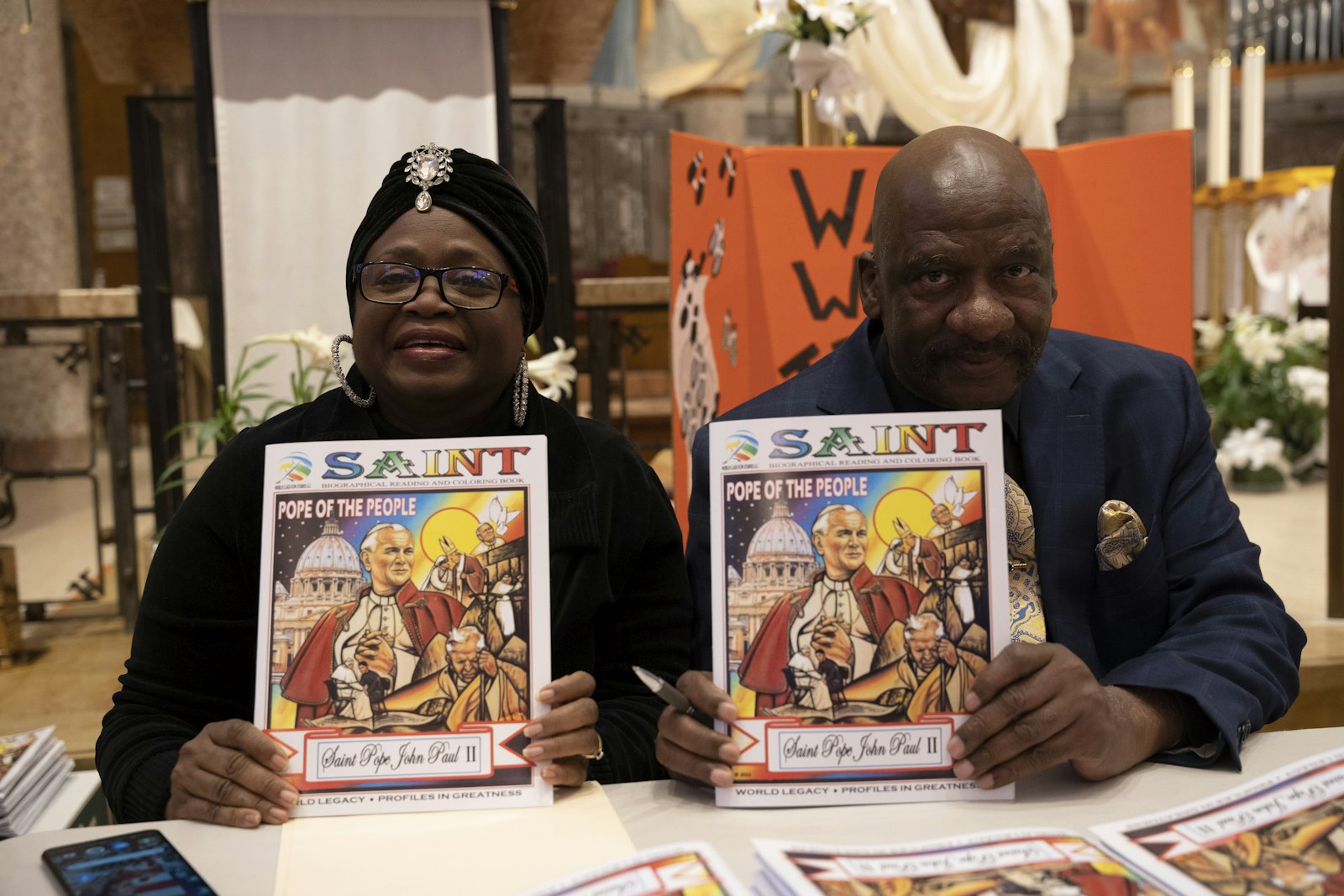 Cynthia Henley and her husband Curtis Lewis hold up the coloring book they co-created. Although the husband and wife team are not Catholic, they said that the saint has greatly impacted their lives.