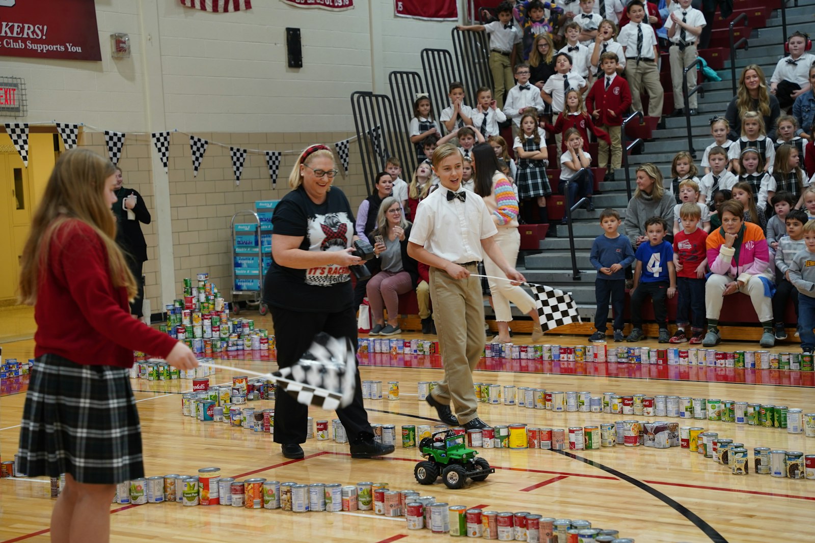 St. Paul on the Lake students assembled a race track on the floor of the school gym, where the school's principal, assistant principal and a priest from the parish raced remote-control cars before a school assembly. The winning classes in the school that donated the most food were awarded with a pizza party. (Daniel Meloy | Detroit Catholic)