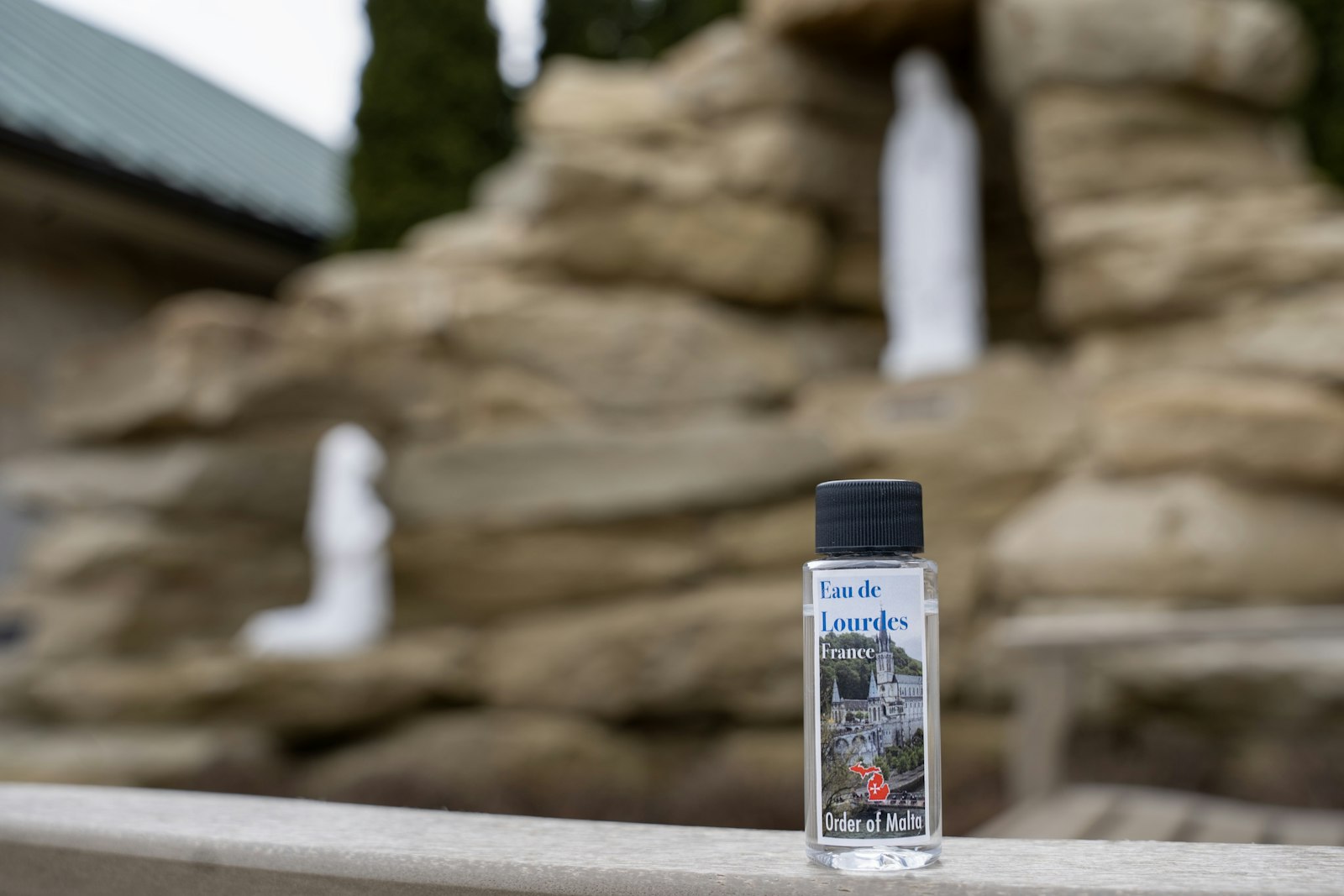 A vial of holy water given out during the Mass is pictured in front of a newly installed grotto dedicated to Our Lady of Lourdes at the cathedral. During the pandemic, Archbishop Vigneron pledged to build the grotto as a "lasting sign" of the Archdiocese of Detroit's gratitude to her protection, a project that is nearly completed and will be dedicated on May 12.
