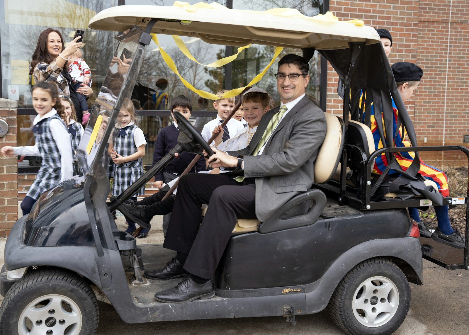 Everest headmaster and high school principal Gregory Reichart drives "Pope Donovan" and his Swiss Guards to the high school in a makeshift "popemobile."