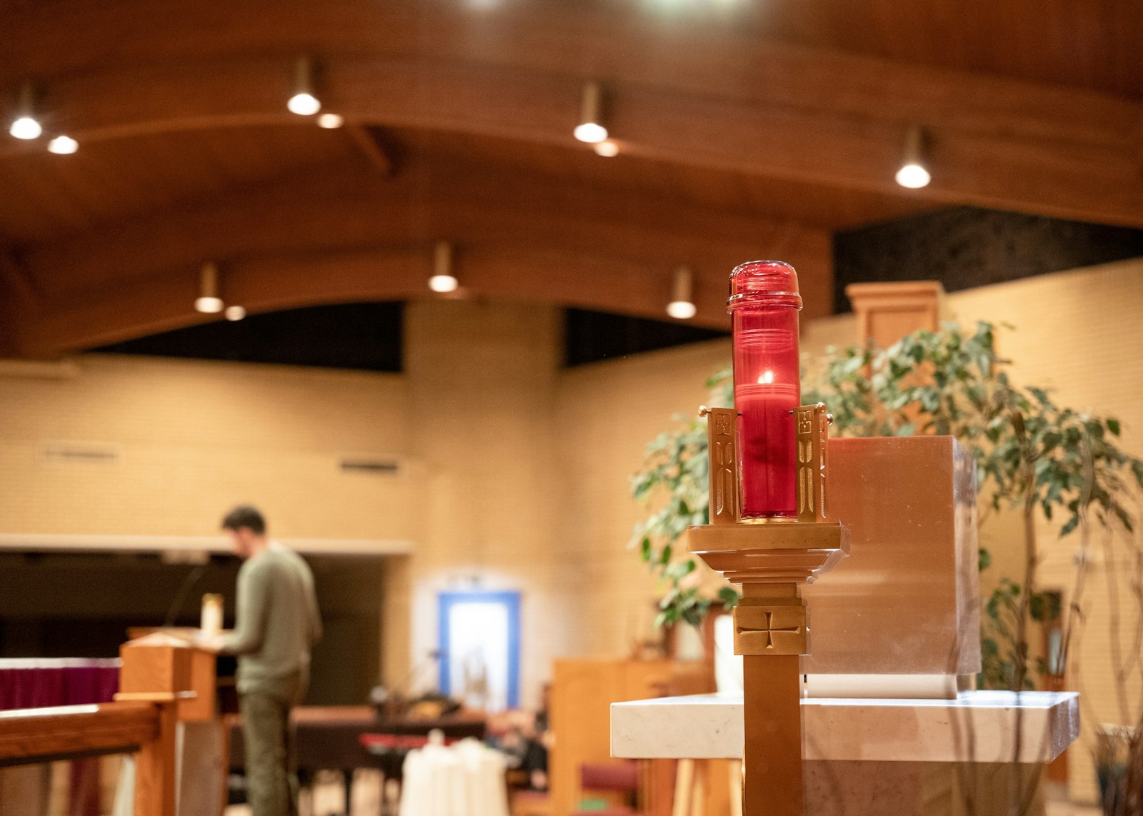 An image of the "ever-lit" flame signifying the presence of the Eucharist in the tabernacle, as Nick Switzer shares his testimony in the background.