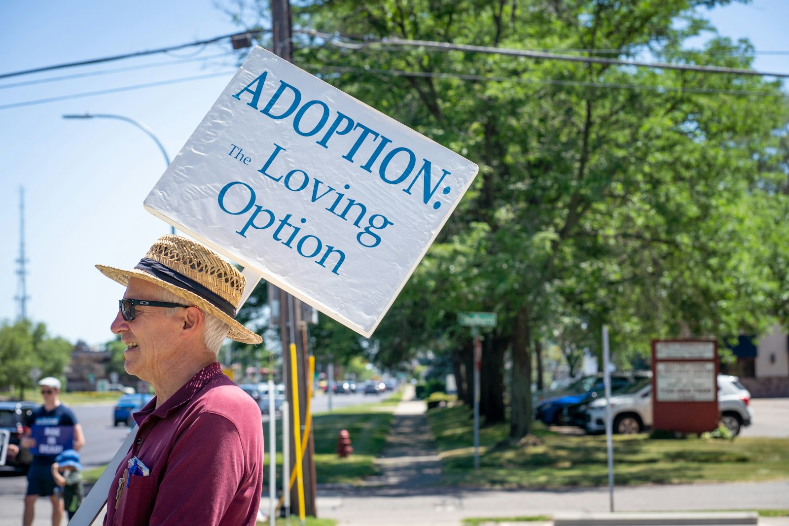 Louis Barrett, de la Parroquia de Santa Priscilla, en Livonia, sostiene un cartel que anima a la adopción, mientras él y otros católicos provida se manifiestan en acción de gracias el 24 de junio.