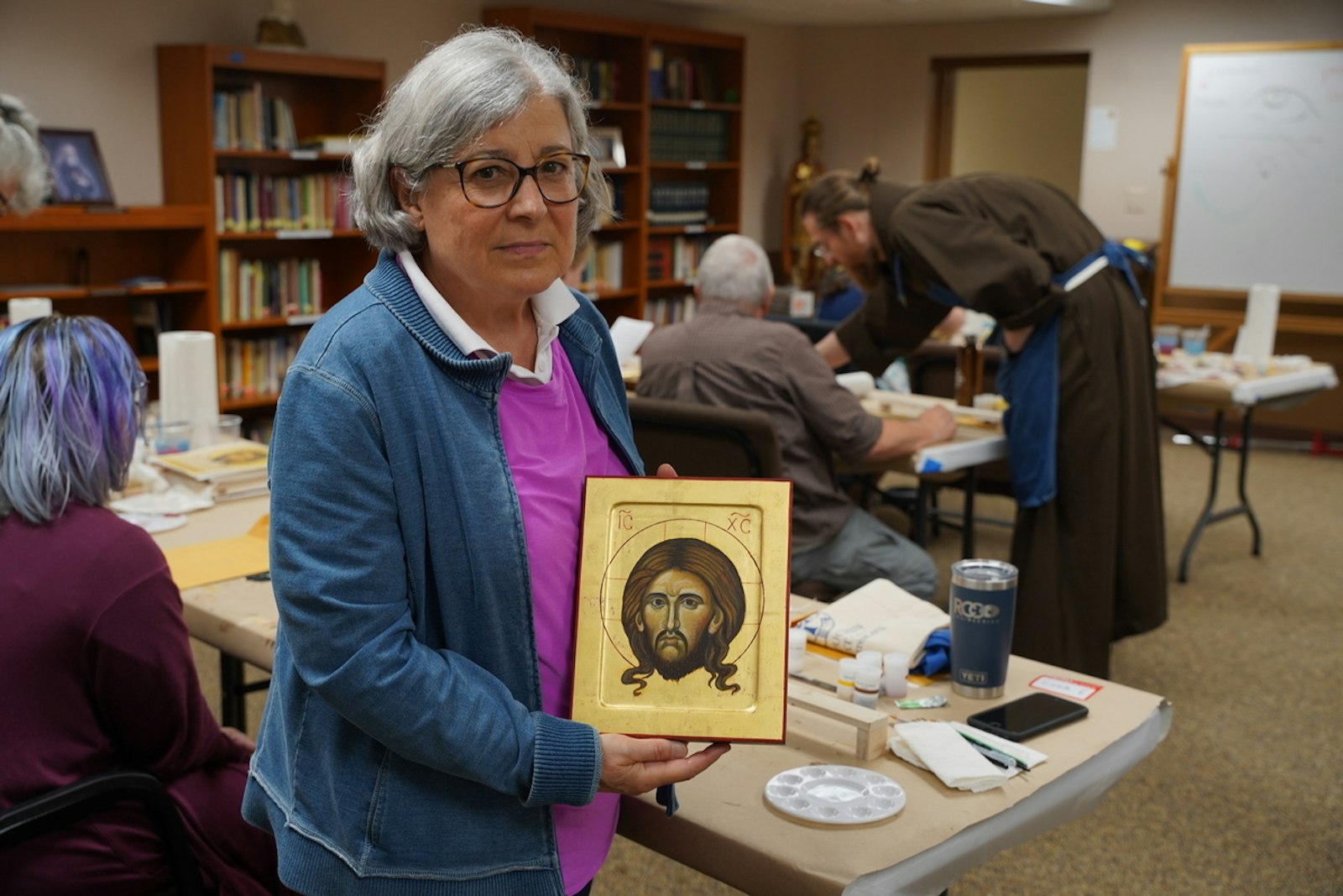 Linda Endres, a parishioner of St. Michael the Archangel Parish in Sterling Heights, shows her completed icon. Throughout the week, Endres said she experienced various highs and lows while writing her icon.