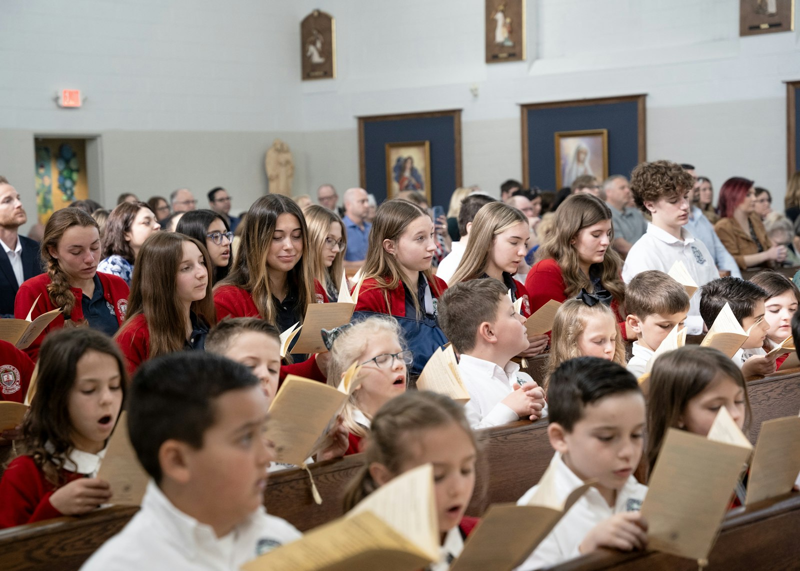 Students from St. Mary School sing during the dedication Mass for the school's new chapel on April 16.
