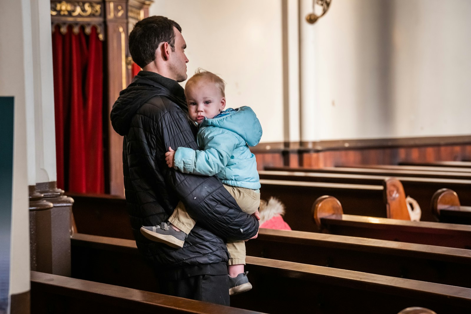 A child clings to her father during a children's holy hour at St. Joseph Shrine in Detroit. At these holy hours, the joyful noises of babies and squirming young ones is welcome and expected. (Valaurian Waller | Detroit Catholic)