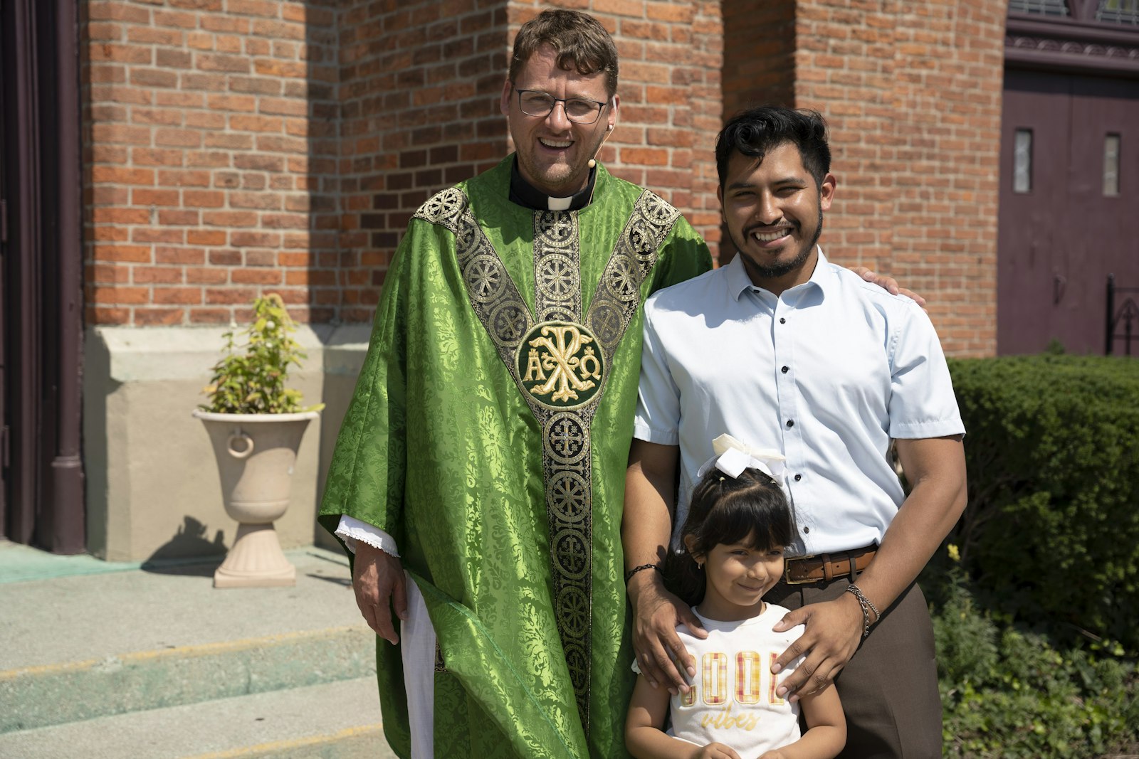 Fr. Adams poses for a picture alongside Most Holy Trinity parishioners Arturo and Casey Medina. Fr. Adams bid farewell to his parishioners following Mass, but told them he would be back to visit. (Gabriella Patti | Detroit Catholic)