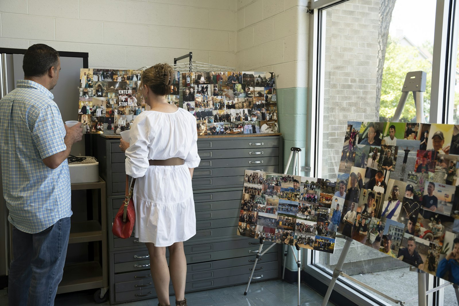 Parishioners look at photo collages made to honor Fr. Adams' six years at Most Holy Trinity and the Basilica of Ste. Anne after Sunday Mass on Aug. 20. (Gabriella Patti | Detroit Catholic)