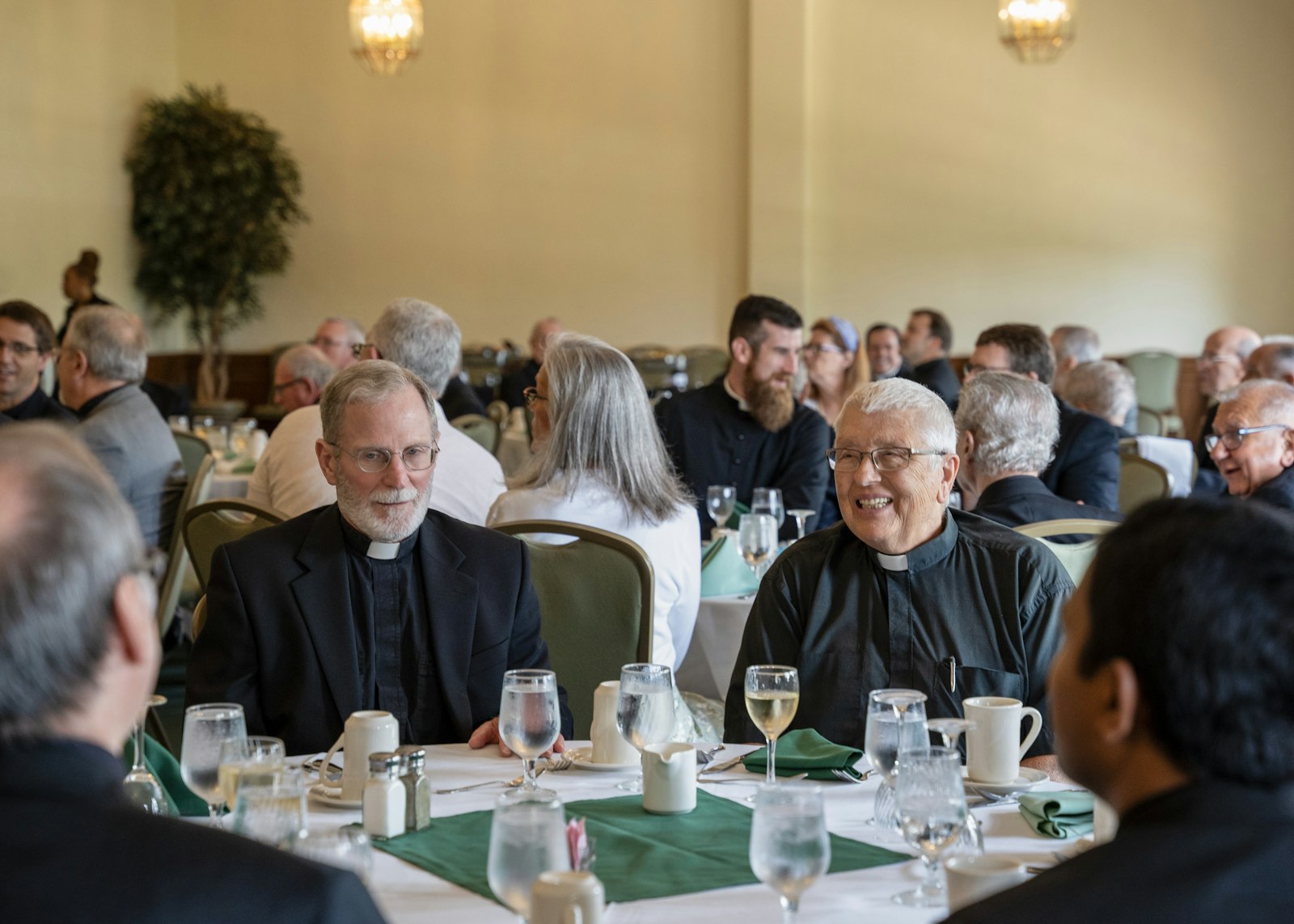 Fr. John Esper, left, and Fr. Richard Treml, right, converse during a luncheon celebrating this year's jubilarians. Fr. Treml is celebrating his 25th jubilee this year.