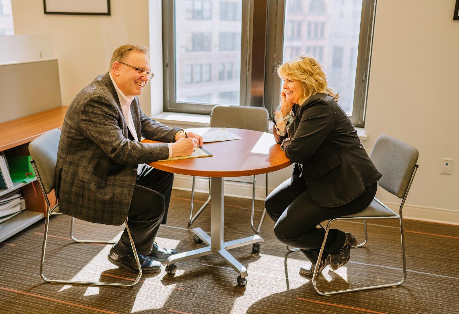Deacon Michael Houghton, left, and Mary Martin, co-founders of the new apostolate UTG at Work, discuss plans for the ministry at the Archdiocese of Detroit's Chancery building in downtown Detroit in June. (Valaurian Waller | Detroit Catholic)