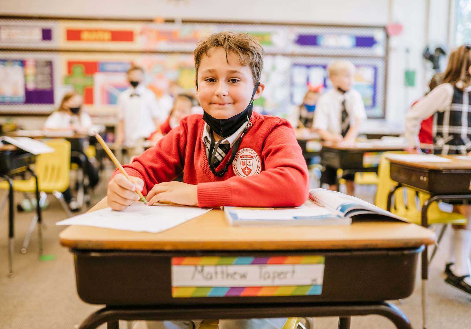 Un estudiante sonríe durante una tarea en la escuela St. Paul on the Lake en Grosse Pointe Farms. Además de la inscripción constante, las escuelas católicas se han desempeñado mejor académicamente desde la pandemia que sus contrapartes de escuelas públicas.